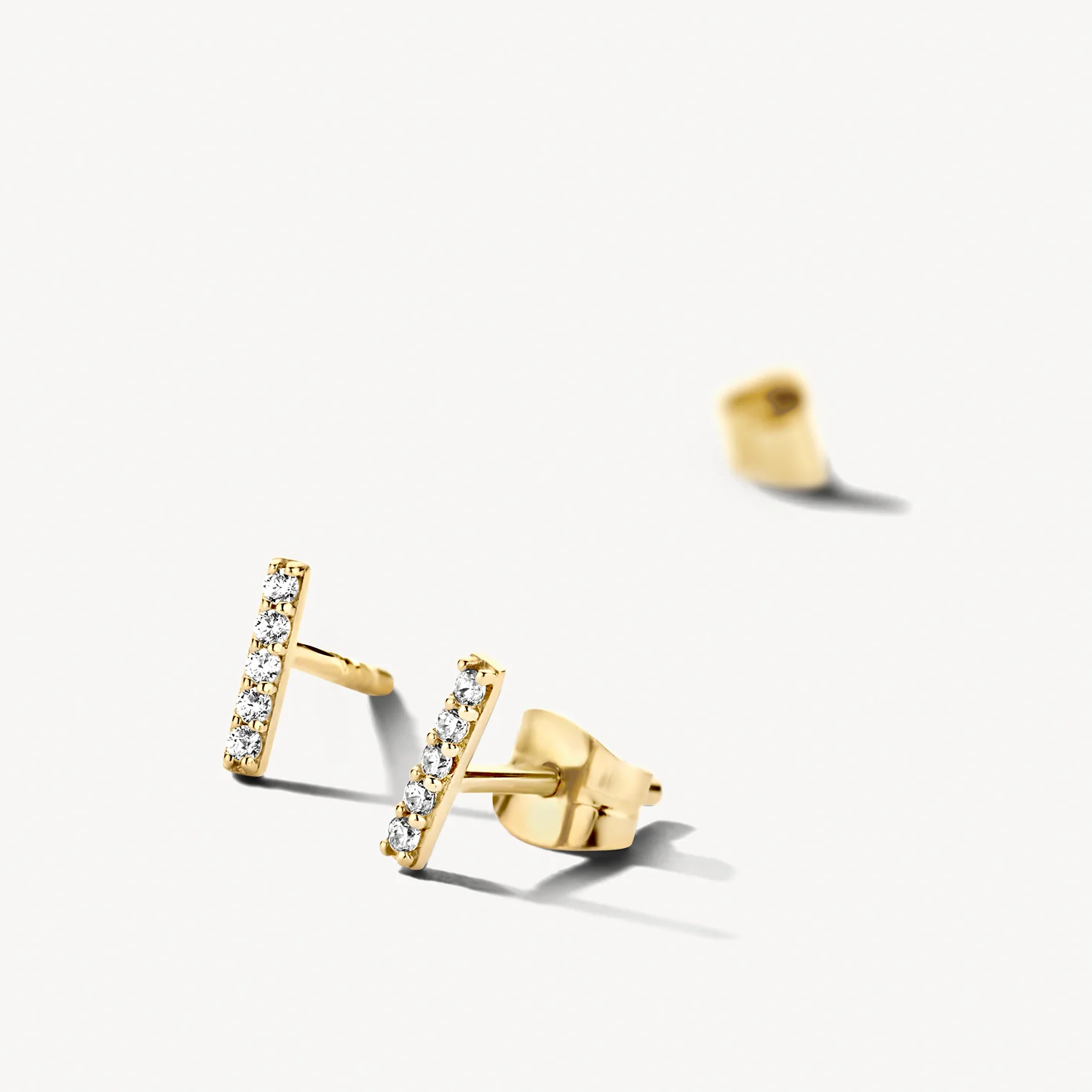 De briljantgeslepen witte zirkonia’s in 14k geelgouden pavézetting geven een mooie sprankeling aan deze tijdloze staafvormige oorknoppen. Ze hebben een dikte van 1,3 mm en een lengte van 6,5 mm en gaan heel goed samen met andere (oor)sieraden uit onze collectie.