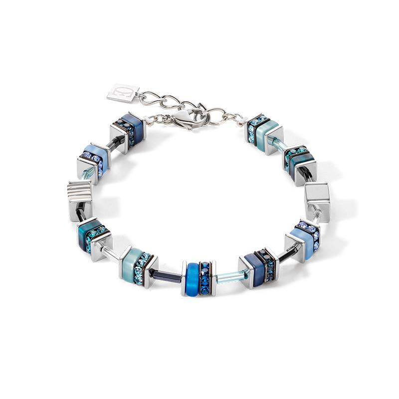 Roestvrijstalen armband Blue uit de GeoCUBE collectie van Coeur de Lion, handgeregen in Duitsland, nieuw in geschenkverpakking. De armband is geregen met blokjes in verschillende tinten blauw, met kristallen en strassrondellen en zilverkleurige roestvrijstalen vierkante schijfjes. De armband heeft en draaglengte van 18 tot en met 21 cm, ook geschikt voor een wat bredere pols. Dikte van de blokjes is 0,8 cm. 