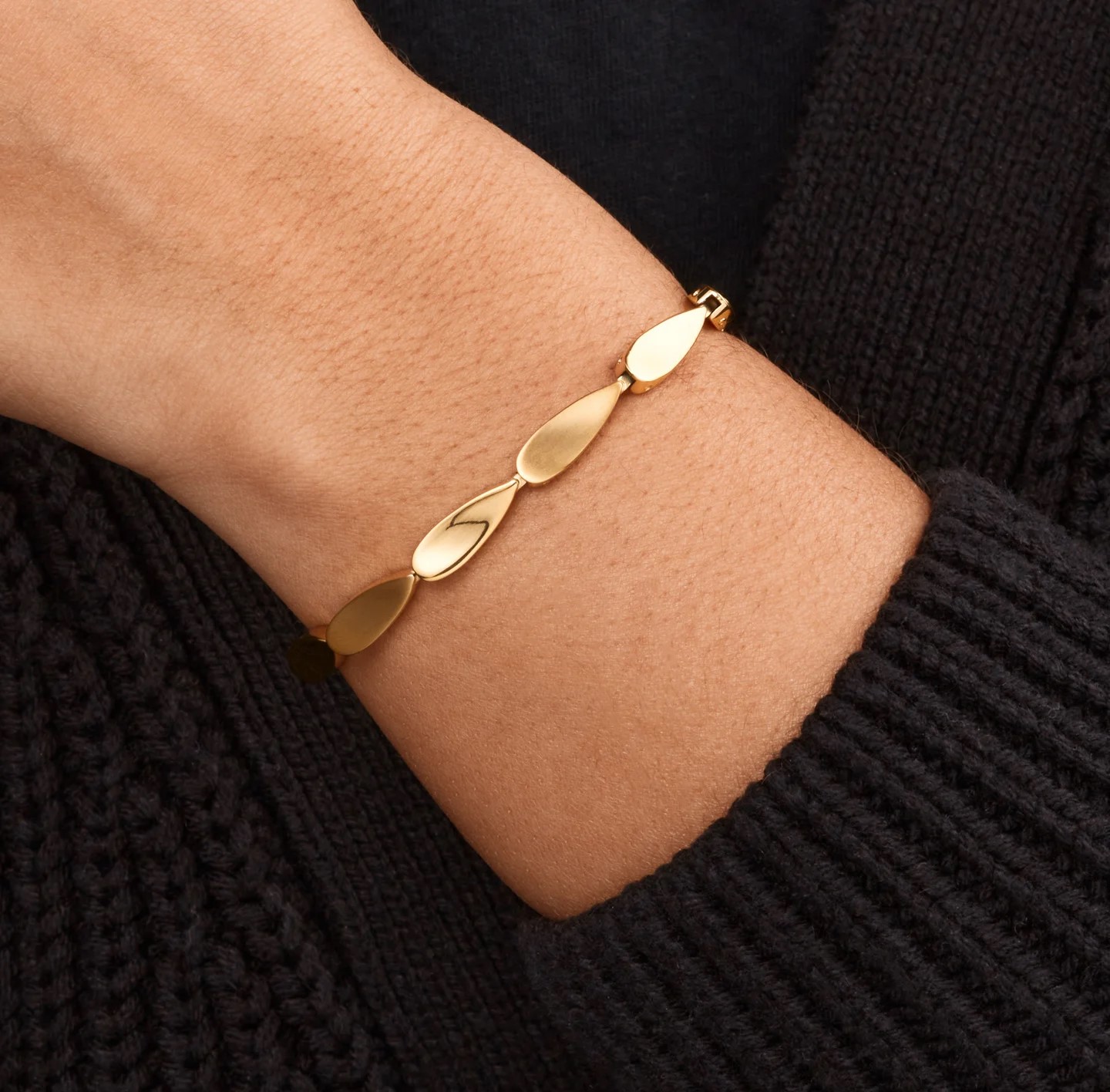 Wat deze goudkleurige armband uniek maakt, is dat er mat en glanzende druppelvormige schakels aan elkaar verbonden zijn.