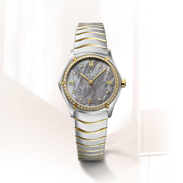 
Het Sport Classic dameshorloge van Ebel is een klassiek model. Het horloge heeft een Zwitsers quartz uurwerk dat geplaatst is in een edelstalen kast afgedekt met een 18Krt gouden lunette bezet 47 diamanten. De diameter van de kast is 29 mm. ook de parelmoer wijzerplaat heeft diamanten uur markeringen. Aan de kast zit de bekende EBEL wave schakelarmband.
De horlogekast is 5 ATM waterdicht en is voorzien van saffierglas met anti-reflectie behandeling.