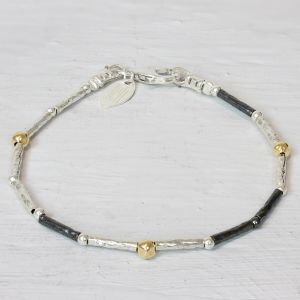 Armband  van Jéh Jewels gemaakt met buisjes van zilver en geoxideerd zilver met daartussen goldfilled balletjes. Ideaal om te matchen met het bijpassende collier.

Materiaal: 925 sterling zilver
De glans van 925 sterling zilver maakt het een gewild edelmetaal voor de vervaardiging van sieraden. Het bestaat uit 92,5% puur zilver en 7,5% koper. Puur zilver is een zacht en buigzaam materiaal, het koper in 925 sterling zilver zorgt voor de stevigheid. De sieraden van Jéh Jewels zijn nikkel vrij.

Materiaal: Geoxideerd zilver
Op dit sieraad is gebruik gemaakt van geoxideerd zilver, dit is een oppervlakte bewerking. Het is mogelijk dat de geoxideerde laag na verloop van tijd door slijtage gaat vervagen.

Materiaal: Goldfilled
Goldfilled komt uit Amerika en wordt daar al langer gebruikt voor de vervaardiging van sieraden met een "touch of gold" voor een betaalbare prijs. Het goldfilled blijft op kleur, is slijtvast en de goudlaag is dik genoeg om lang te kunnen genieten van de warme uitstraling van goud. Goldfilled wordt veelal ook goed verdragen door mensen die allergisch zijn voor andere metalen dan goud.