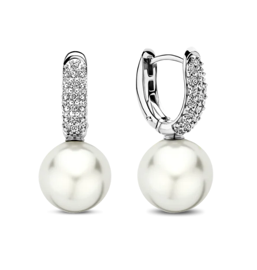 Verlies jezelf in de etherische schoonheid van de TI SENTO Silver Pearl Earrings 7985PW. Gemaakt van 925 sterling zilver en verguld met platina voor een blijvende schittering, deze oorbellen hebben betoverende ronde parels met een unieke fantasiesnede. De onregelmatige vorm van de parels voegt een vleugje speelsheid en individualiteit toe aan het ontwerp. Een schitterende pave van witte cubic zirconia stenen creëert een fonkelende halo. Deze oorbellen zijn een bewijs van de kunst van fijne sieraden, en bieden een harmonieuze mix van traditie en hedendaagse stijl. De combinatie van de natuurlijke schoonheid van de parel en de glinstering van de cubic zirconia creëert een betoverend effect. Laat ze het middelpunt zijn van je verfijnde esthetiek. Draag ze alleen voor een minimalistische uitspraak of gecombineerd met andere TI SENTO oorbellen voor een persoonlijke touch die moeiteloze chic uitstraalt.