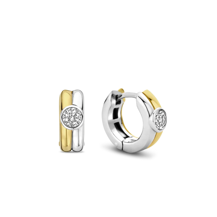 Omarm de aantrekkingskracht van contrasterende texturen met deze TI SENTO gold-plated silver Hoop Earrings 7980ZY. Gemaakt van 925 sterling zilver en verzilverd voor blijvende schittering, hebben deze oorbellen twee onderling verbonden hoepels, de ene verguld met glanzend geelgoudkleurig en de andere vervaardigd uit puur zilver. In het midden van de hoepels voegt een schitterende witte cubic zirconia steen een vleugje sprankeling en magie toe. Laat deze stukken een vleugje escapisme aan je dagen en nachten toevoegen. Verhoog je dagelijkse look met deze minimalistische schoonheid. Draag ze alleen voor een minimalistische uitspraak of gelaagd met andere TI SENTO oorbellen voor een gepersonaliseerde touch die vertrouwen en allure uitstraalt. Met zorg vervaardigd voor gevoelige huid, zorgen deze nikkelvrije en hypoallergene oorbellen voor langdurig comfort en kwaliteit.