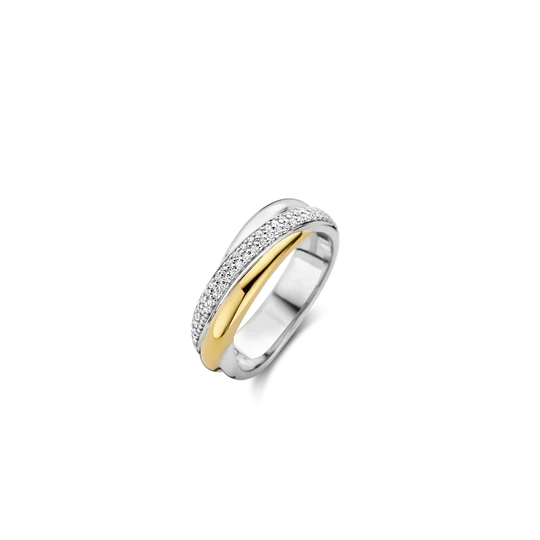 Ervaar hedendaagse elegantie met de TI SENTO gouden ring 12343ZY. Dit betoverende sieraad heeft twee vloeiende ringen die elkaar elegant kruisen, wat zorgt voor een dynamisch en opvallend ontwerp. De ene ring is bezet met schitterend pavé van witte zirconia-stenen en de andere ring is verguld met een stralende goudkleur. Het contrast tussen het romantische pavé en warm, rijke goudkleur geeft een betoverende uitstraling aan je handen. Gemaakt van 925 sterling zilver en verzilverd voor langdurige schittering, is deze ring een voorbeeld van moderne luxe. De vloeiende lijnen en harmonieuze mix van materialen maken het een werkelijk uitzonderlijk sieraad. Versterk je dagelijkse look met deze verfijnde accessoire. Met zorg vervaardigd voor gevoelige huid, zorgt deze nikkelvrije en hypoallergene ring voor langdurig comfort en kwaliteit.
