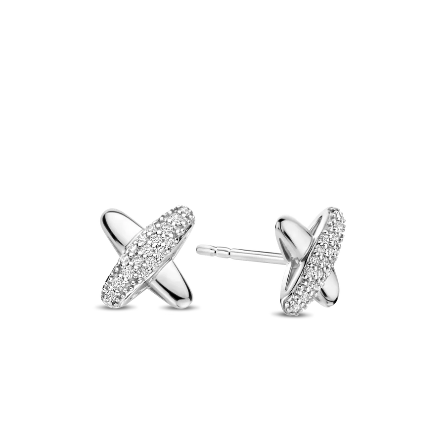 Omarm tijdloze en moderne elegantie met deze TI SENTO Silver Stud Earrings 7982ZI. Gemaakt van 925 sterling zilver en verguld met een waardevolle laag platina, hebben deze oorbellen een delicate kruisontwerp. Twee in elkaar verstrengelde ringen vormen het kruis, waarvan één is versierd met een schitterende pave van cubic zirconia die het licht prachtig vangt. De platina plating zorgt voor een blijvende schittering, waardoor het zilver stralend blijft en beschermd tegen krassen. Deze veelzijdige studs bieden een vleugje Art Deco-geïnspireerde stijl die elke outfit aanvult. De combinatie van klassieke symboliek en modern ontwerp maakt ze perfect voor dagelijks gebruik of speciale gelegenheden. Draag deze zilveren studs solo voor een vleugje ingetogen elegantie, of combineer ze met andere TI SENTO-stukken voor een gepersonaliseerde look die je individuele stijl weerspiegelt. Met zorg vervaardigd voor gevoelige huid, zorgen deze nikkelvrije en hypoallergene studs voor langdurig comfort en kwaliteit.