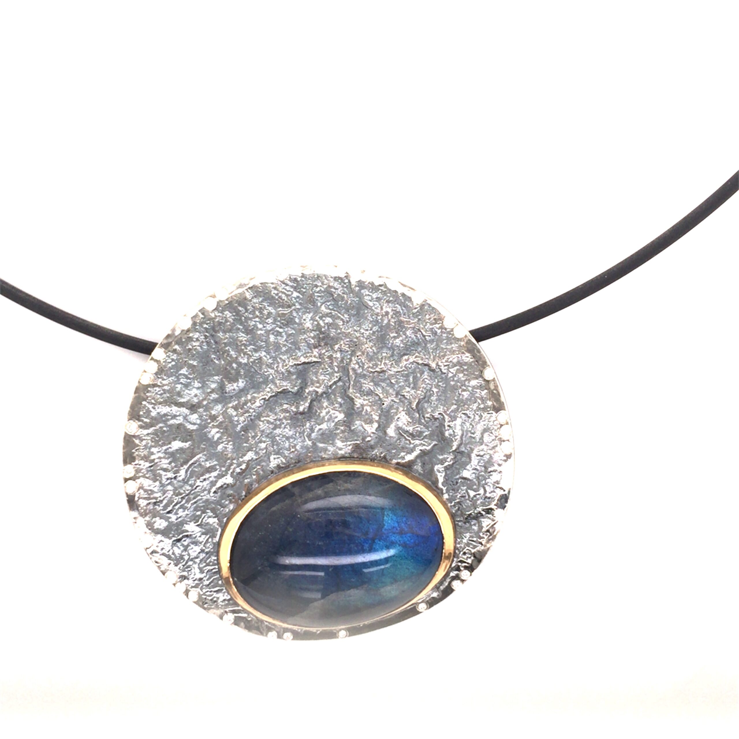 Anhänger und Collierschließe gefertigt in geschwärztem Silber und Gold 900, Labradorit, Durchmesser 60mm. Mit 32 Brillanten, ergeben zusammen 0,16 ct.
UNIKAT

Gefertigt im Atelier Kissner
Design: Carsten Kissner