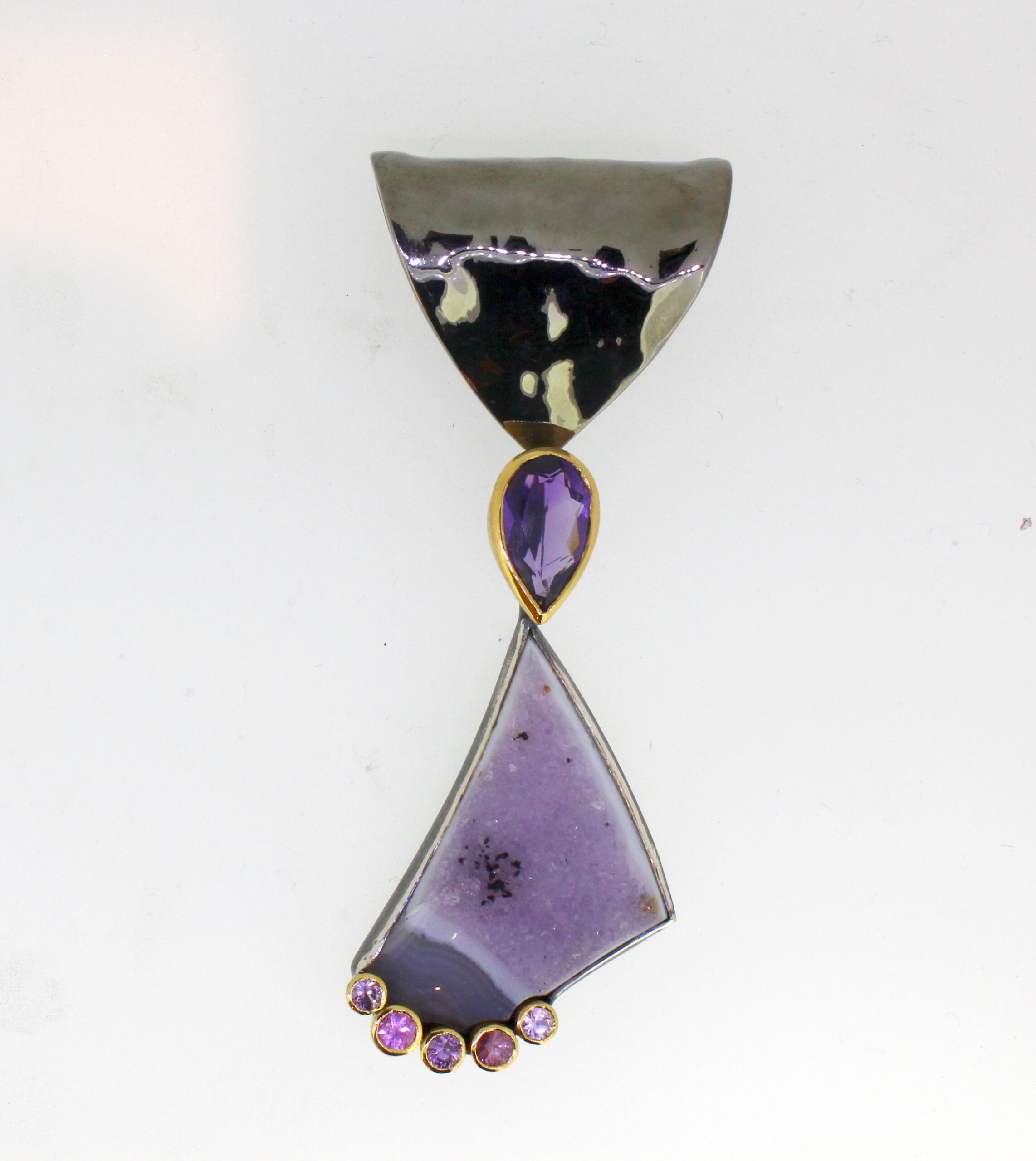 vielseitiger Anhänger in Silber/ Gold 900 mit einem Amethyst, darunter eine Amethystdruse und 5 Safiren. Gesamtlänge 8cm. Beweglich aufgehängt und über dem Amethyst abhängbar. Es können andere Einhänger in das Oberteil eingehängt werden. Mit Sicherung.