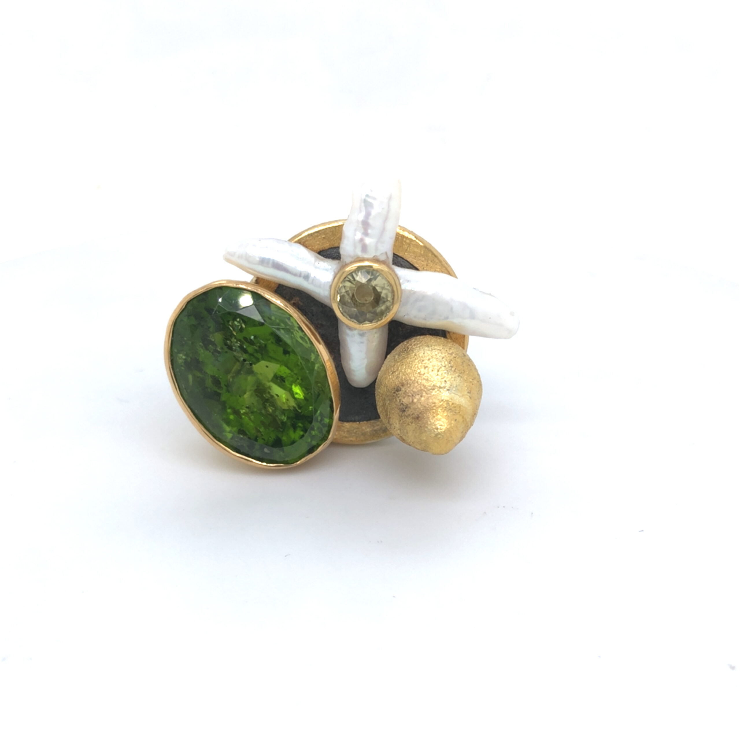 Ausdrucksstarker Ring mit einer Perlblüte mit gelbem Safir, grünem Bewuchs mit einem 24ct Peridot, Zitronenbaum aus geschwärztem Silber und Feingold, Zitrone aus Gold 900. Die Ringröße ist 61, eine Größenänderung auf Anfrag natürlich möglich.

Das Stück ist eine Hommage an mein Preisträgerstück des DSEP von 2004 "Kennst du das Land wo die Zitronen blühen?" 

Design: Carsten Kissner
UNIKAT: Gefertigt im KISSNER Meisteratelier