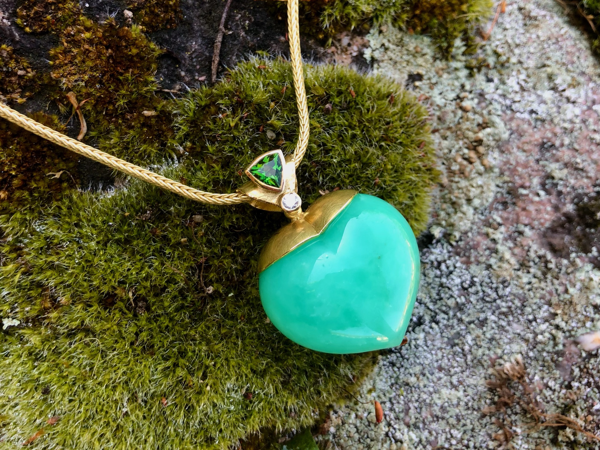 Erfrischend grüner Anhänger, bestehend aus einem Chrysoprasherz, beweglich in Gelbgold 750 gearbeitet, gekrönte von einem Turmalin Triangel und einem kleinen Brillanten. Er ist sehr schön an einer langen Kette zu tragen. Die Schlaufe hat ein Durchgangsmaß von 5,5mm bis 6mm, somit sind eine große Vielfalt von Ketten oder Seilen möglich.

UNIKAT

gefertigt im KISSNER Meisteratelier
Design: Carsten Kissner