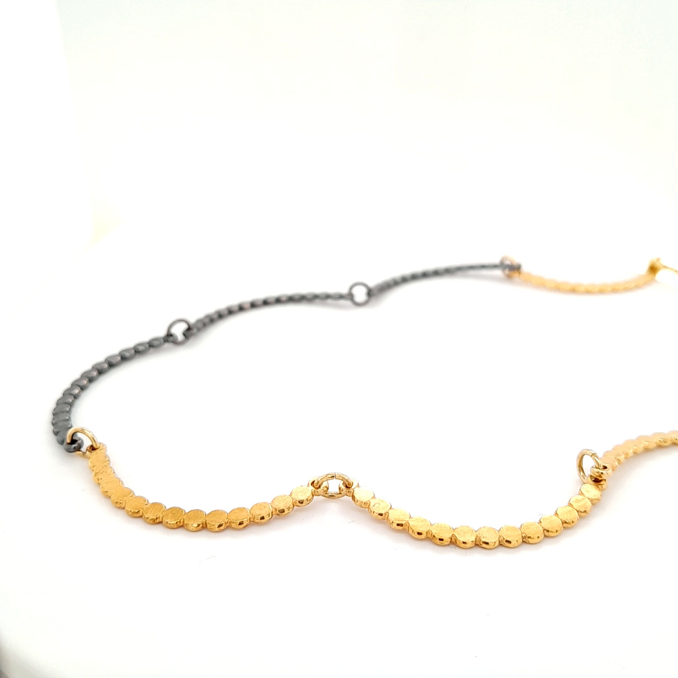 Halsschmuck gefertig in Silber vergoldet und teilweise oxidiert.
Ein Knebelverschluss vollendet das Design.
Länge ca 45 cm
