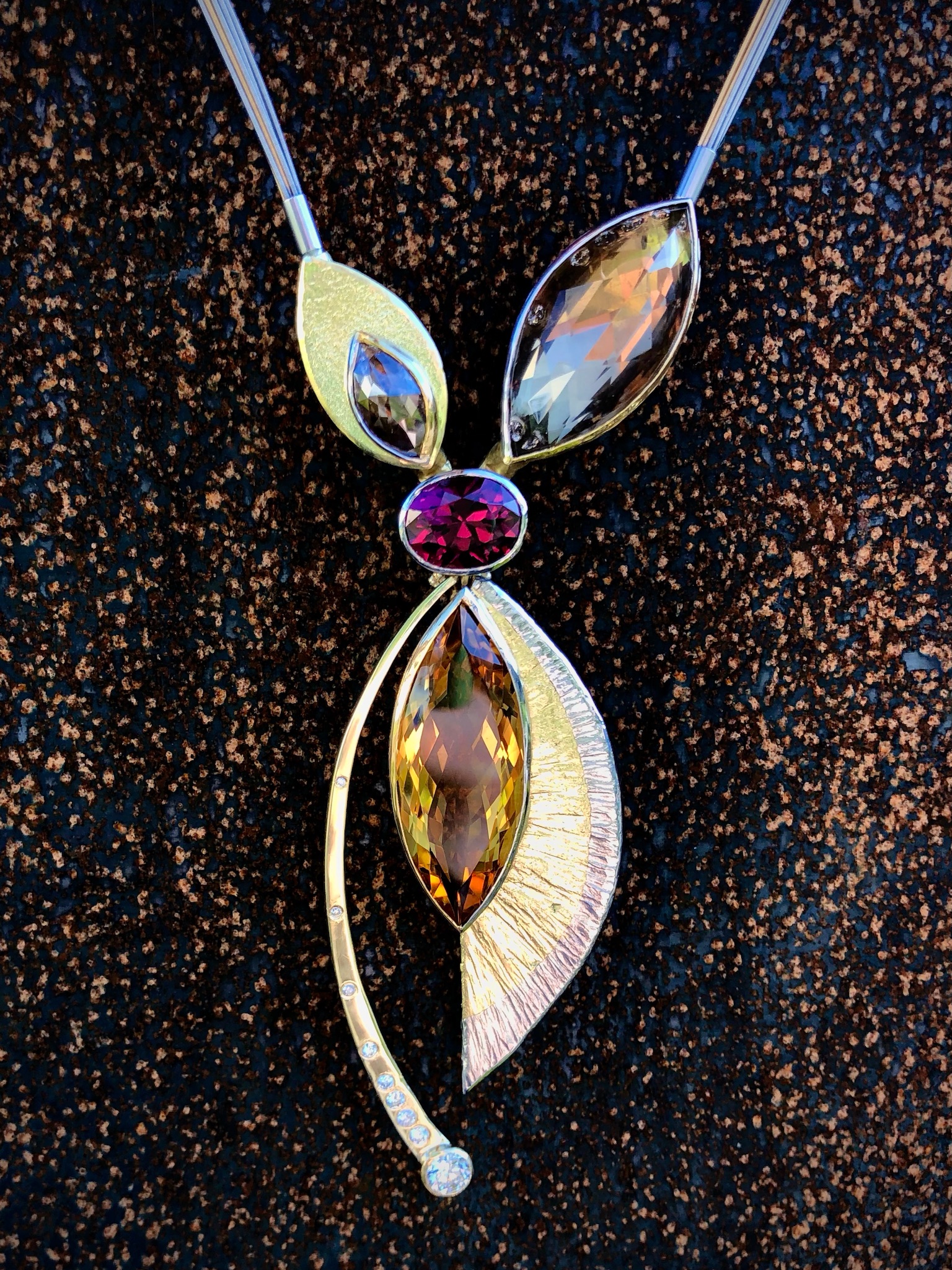 Aufregende und sehr beweglicher Anhänger und Collierschließe in Gold 750, Gold 900 und Platin. Verschiedene Diamanten, ein Citrin und ein Rauchquarz sind um einen erstklassigen Rhodolithen beweglich angeordnet. Die Schließe kann nur mit einem wie dem zugehörigen Seilecollier mit Wechselschließenmechanik (System Nittel) getragen werden. Hierbei sind endlos viele Tragevarianten möglich. Bevorzugt Perlenketten, Steinketten, aber auch Gliederketten können kombiniert werden. 

UNIKAT

Design: Carsten Kissner
gefertigt im KISSNER Meisteratelier