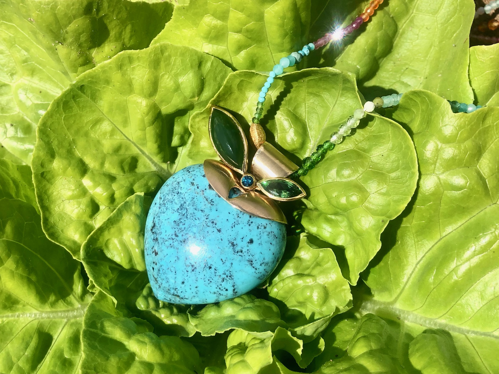 Erfrischend fruchtiger Herzanhänger, gefertigt in Roségold 750 mit einem bauchig geschliffenen Arizona Türkis. Um ein blauen Brillanten sind zwei Blätter beweglich angeordnet,ein facettierter Tsavorit  mit 1,11ct und eine Jade, als Cabochon geschliffen. Der Durchgang der ebenfalls beweglich gefertigten Anhängeschlaufe beträgt etw 5,0mm. Der Anhänger misst 38mm in der Breite und 50mm in der Höhe.

UNIKAT

Design: Carsten Kissner
gefertigt im KISSNER Meisteratelier