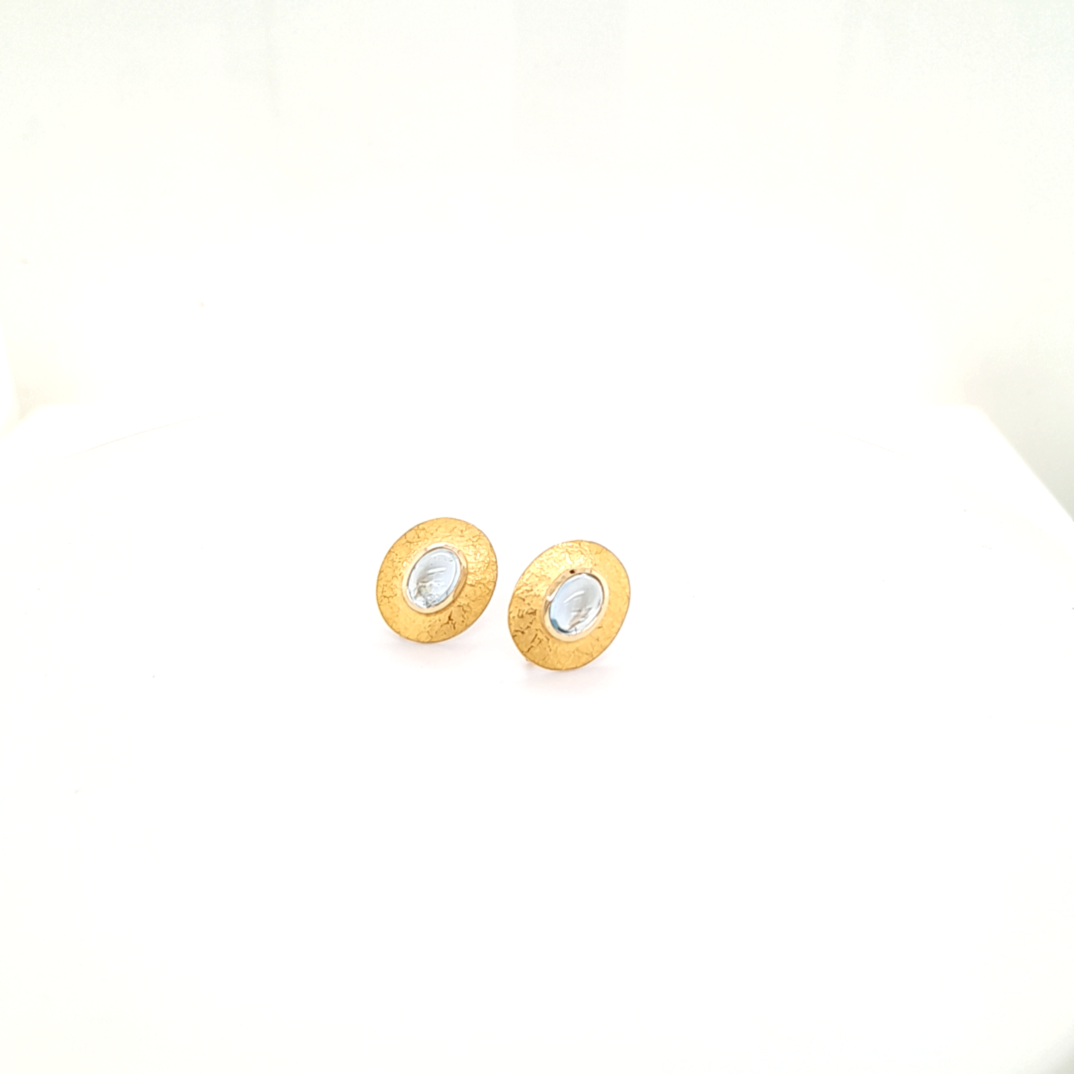 Ohrstecker gefertig in Silber und mit Feingold beschweißt, Oval 14x12 mm, je Seite befindet sich ein Aquamarin Cabochon 7x5mm

Auf der Rückseite des Ohrsteckers befindet sich ein Haken, zum einhängen für Einhänger.