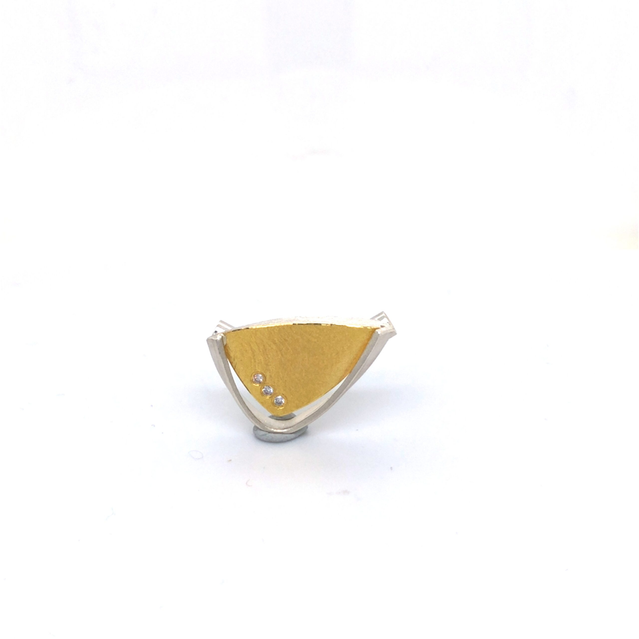 Das Produkt ist eine elegante Collierschließe aus Silber/Gold 900/ooo. Es beinhaltet drei Brillanten mit insgesamt 0,036 ct. Am besten wird es als Blickfang zu einem schlichten Outfit getragen, um die Brillanz zu betonen.