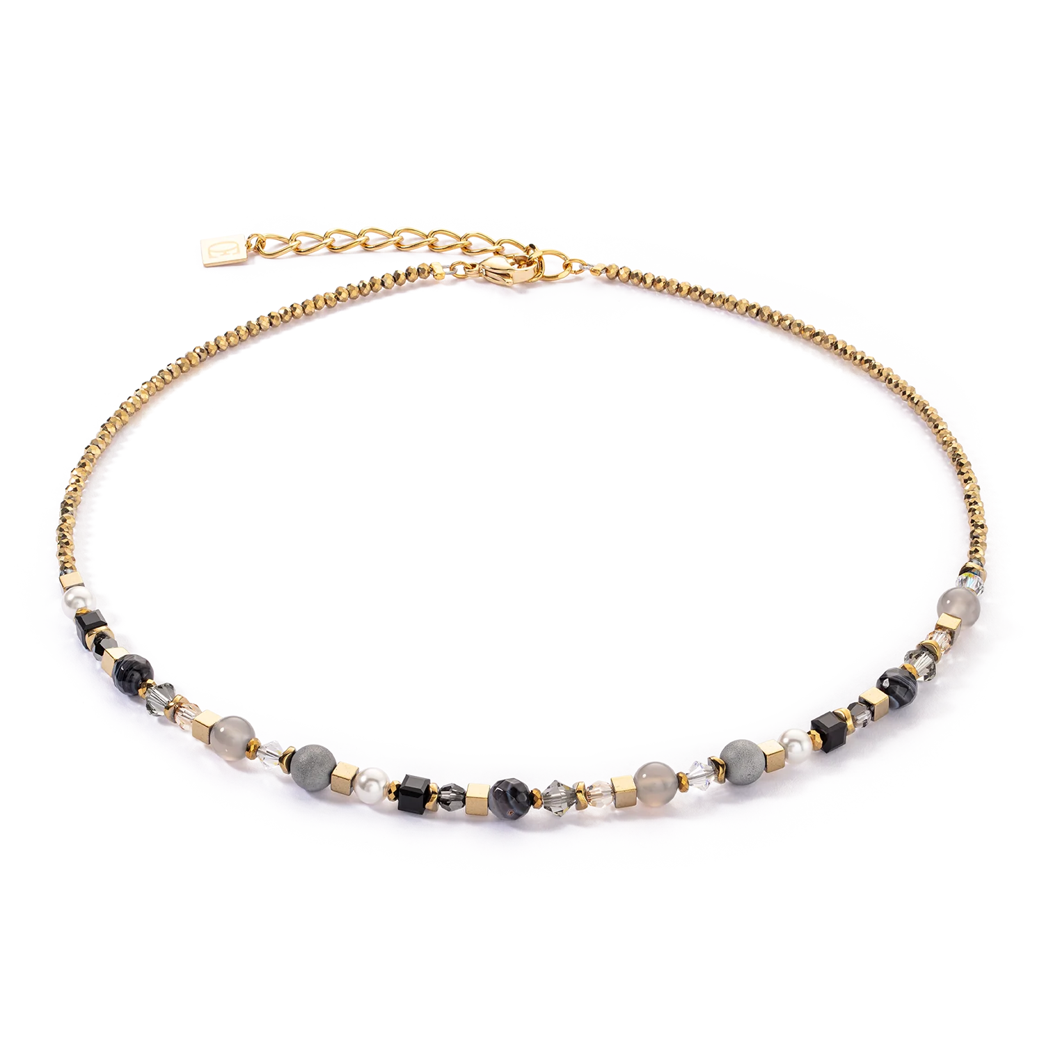 Festive Spheres ketting in goud-grafiet: krachtige edelstenen in een luxueus design De Festive Spheres ketting in goud-grafiet combineert de fascinerende schoonheid van edelstenen met sprankelende schittering om een uniek sieraad te creëren. Deze ketting is een harmonieuze mix van echte stenen bollen zoals gestreepte onyx, agaat en geïoniseerd agaat met kwarts druzen, aangevuld met kostbare kristalparels en glinsterende kristallen. Elk van deze edelstenen heeft een speciale betekenis, waardoor deze ketting niet alleen een stijlvol accessoire is, maar ook een krachtige metgezel. Streep onyx: De streep onyx is een steen van kracht en zelfbeheersing. Het bevordert uithoudingsvermogen en veerkracht, helpt bij het overwinnen van uitdagingen en brengt duidelijkheid in moeilijke situaties. Onyx wordt traditioneel gebruikt om innerlijke stabiliteit en bescherming te bieden. Agaat: Agaat staat bekend als een steen van aarding en stabiliteit. Het bevordert innerlijke rust, zelfvertrouwen en helpt negatieve energieën af te weren. Agaat helpt om harmonie in het leven van de drager te brengen en het emotionele evenwicht te behouden. Agaat geïoniseerd met kwartsdruzen: Deze buitengewone edelsteen combineert de eigenschappen van agaat met de stralingsenergie van kwartsdruzen. Van kwartsdruzen is bekend dat ze de positieve energie verhogen en de verbinding met spirituele krachten versterken. Deze combinatie maakt de steen tot een krachtig symbool van spirituele groei en innerlijke genezing. Deze luxe ketting is perfect voor speciale gelegenheden of om een krachtige, elegante touch toe te voegen aan je dagelijkse look. De Festive Spheres Gold Graphite Necklace combineert de diepe betekenis van edelstenen met een verbluffend ontwerp van Crystal Pearls en sprankelende kristallen. Draag deze ketting als een uitdrukking van stijl, kracht en innerlijke harmonie.