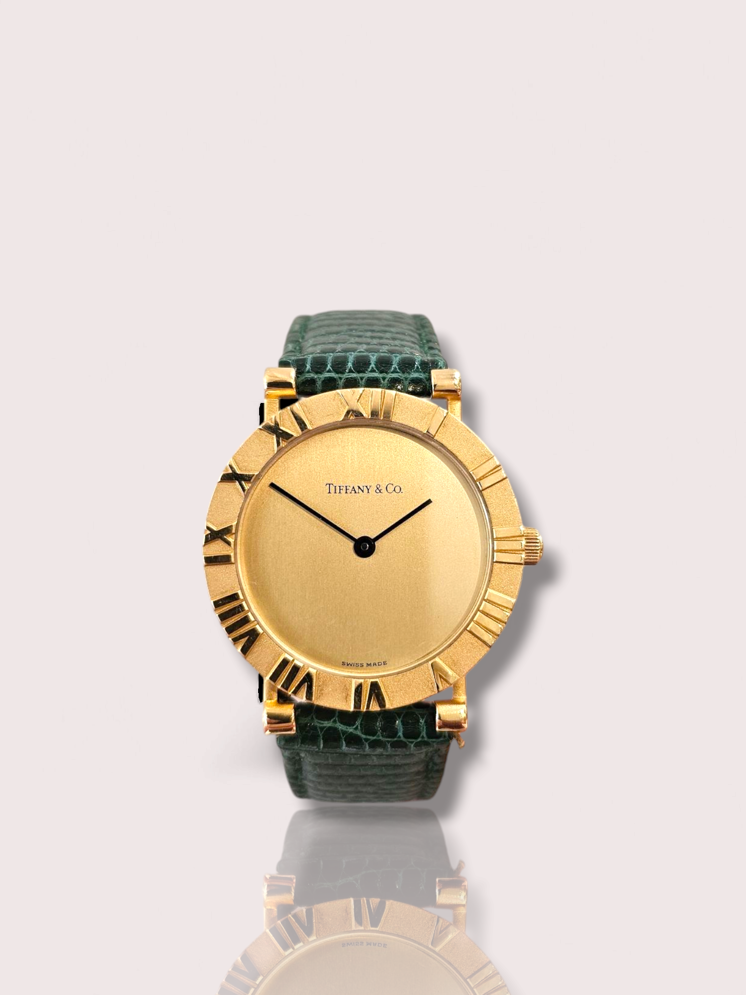 Tiffany & Co Atlas horloge met een elegant design, een groene leren band en een 18 karaat gouden kast. Het horloge is perfect voor dagelijks gebruik of speciale gelegenheden. Draag het met je favoriete outfit voor een stijlvolle en luxueuze uitstraling. Dit tijdloze accessoire zal zeker de show stelen waar je ook gaat. Maak je look compleet met dit prachtige horloge van Tiffany & Co!