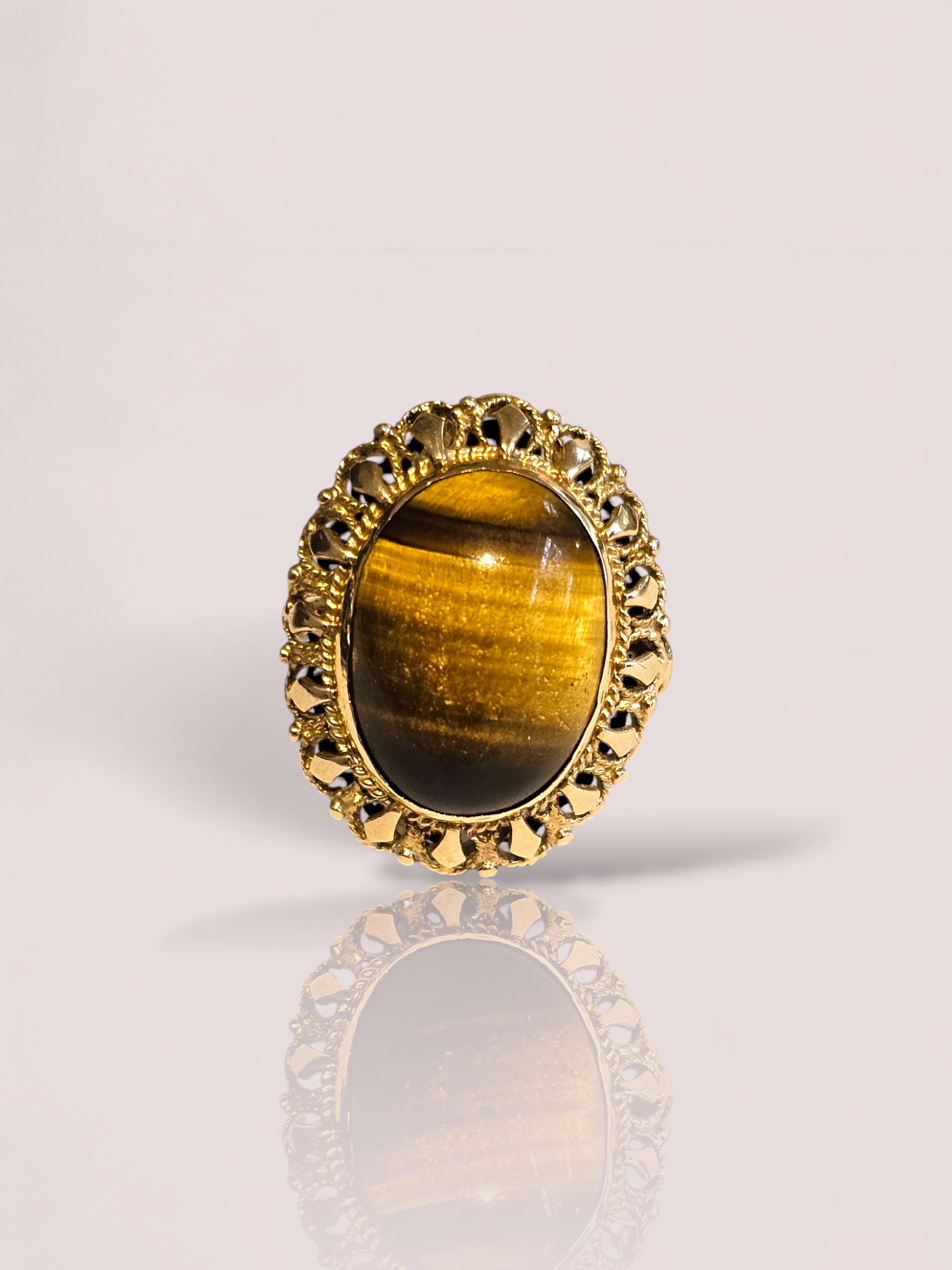 Deze prachtige ring is gemaakt van 14k geel goud en heeft een tijgeroog steen die bekend staat om zijn beschermende en stabiliserende eigenschappen. De ring heeft een elegante en tijdloze uitstraling die perfect is voor zowel dagelijkse als speciale gelegenheden. Draag deze ring alleen of combineer hem met andere gouden sieraden voor een verfijnde look. De tijgeroog is 2 bij 1,5 cm.