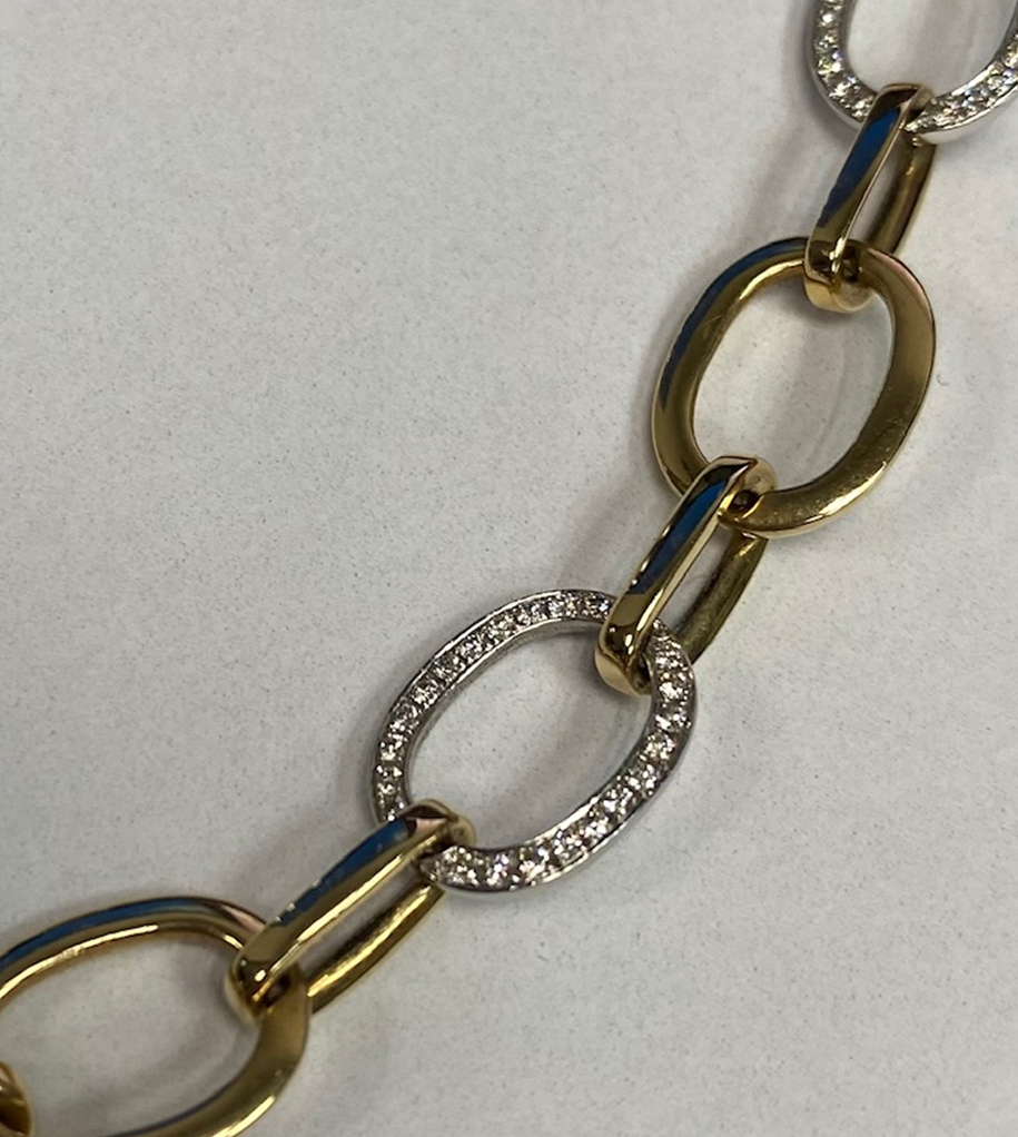 Exclusief 14 karaat geel collier bestaande uit ovaal gelinkte schakels waarvan 11 in witgoud en pavé gezet met fijne briljant. Totaal 1.24 crt H/SI-1.
