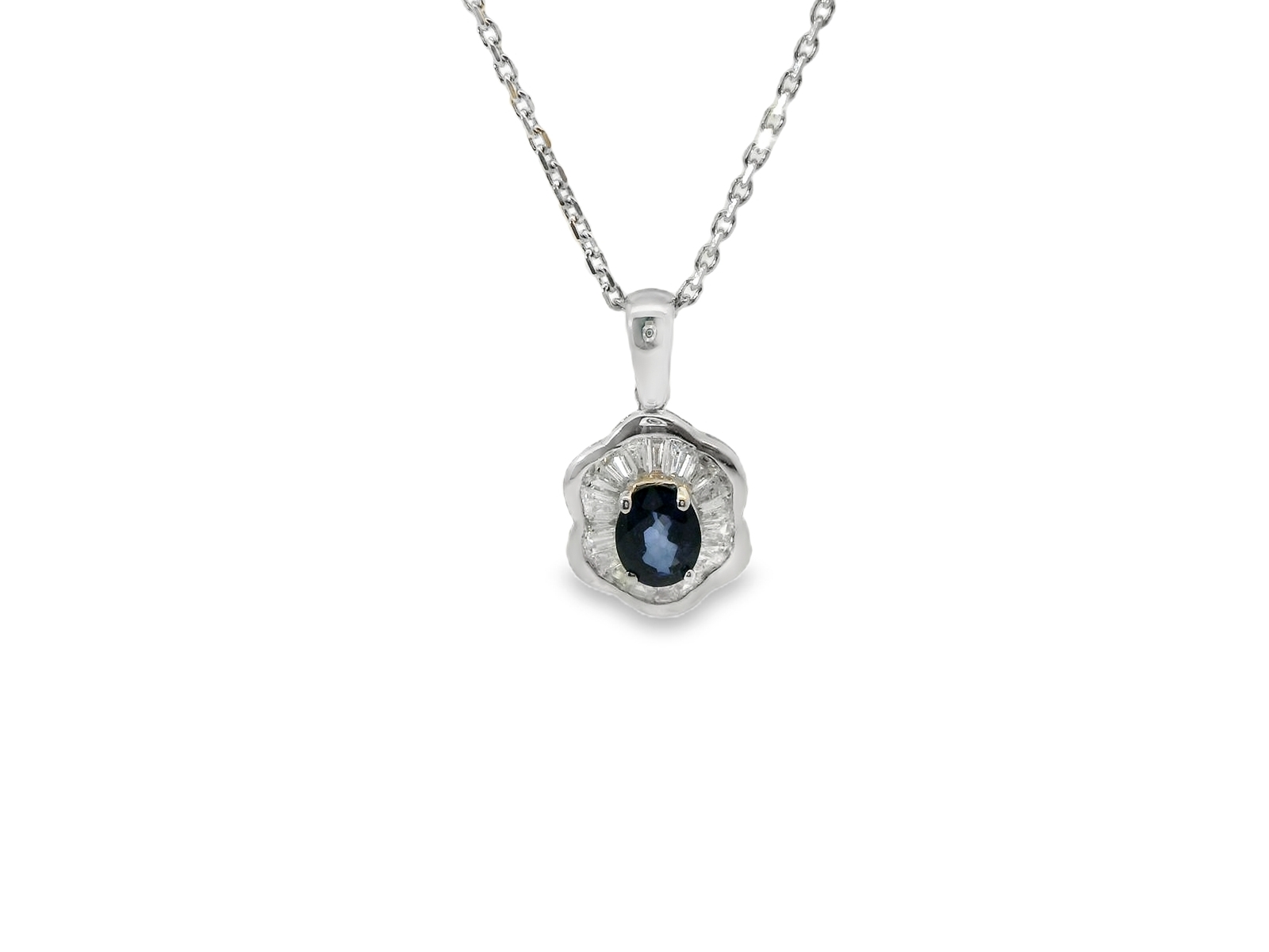 Deze hanger (inclusief collier) van Louis Bros is vervaardigd uit 18 karaat witgoud (2.77 gr.) en is gezet met 1 saffier 0.35ct en 19 baguette geslepen diamanten met een totaalgewicht van 0.19 ct. 
Deze elegante witgouden hanger met collier heeft een schitterende blauwe saffier in het middelpunt, omlijst door baguette-geslepen diamanten in een klassiek design. De combinatie van de verfijnde saffier, sprankelende baguette-diamanten en de koele glans van het witgoud geeft dit sieraad een tijdloze en luxe uitstraling. Perfect om elke outfit een vleugje klassieke verfijning te geven.