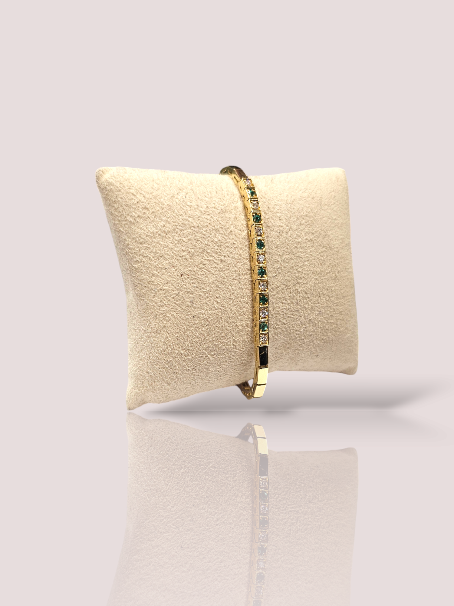 Deze vintage 18k geel gouden armband is versierd met smaragd en diamant voor een luxe uitstraling. De armband voegt een vleugje elegantie toe aan elke outfit en is perfect voor speciale gelegenheden. Draag het alleen of stapel het met andere armbanden voor een trendy look. Verkrijgbaar in onze webshop voor een glamoureuze toevoeging aan je sieradencollectie. De armband is 18,5 cm lang en voorzien van een extra veiligheidssluitinkje.