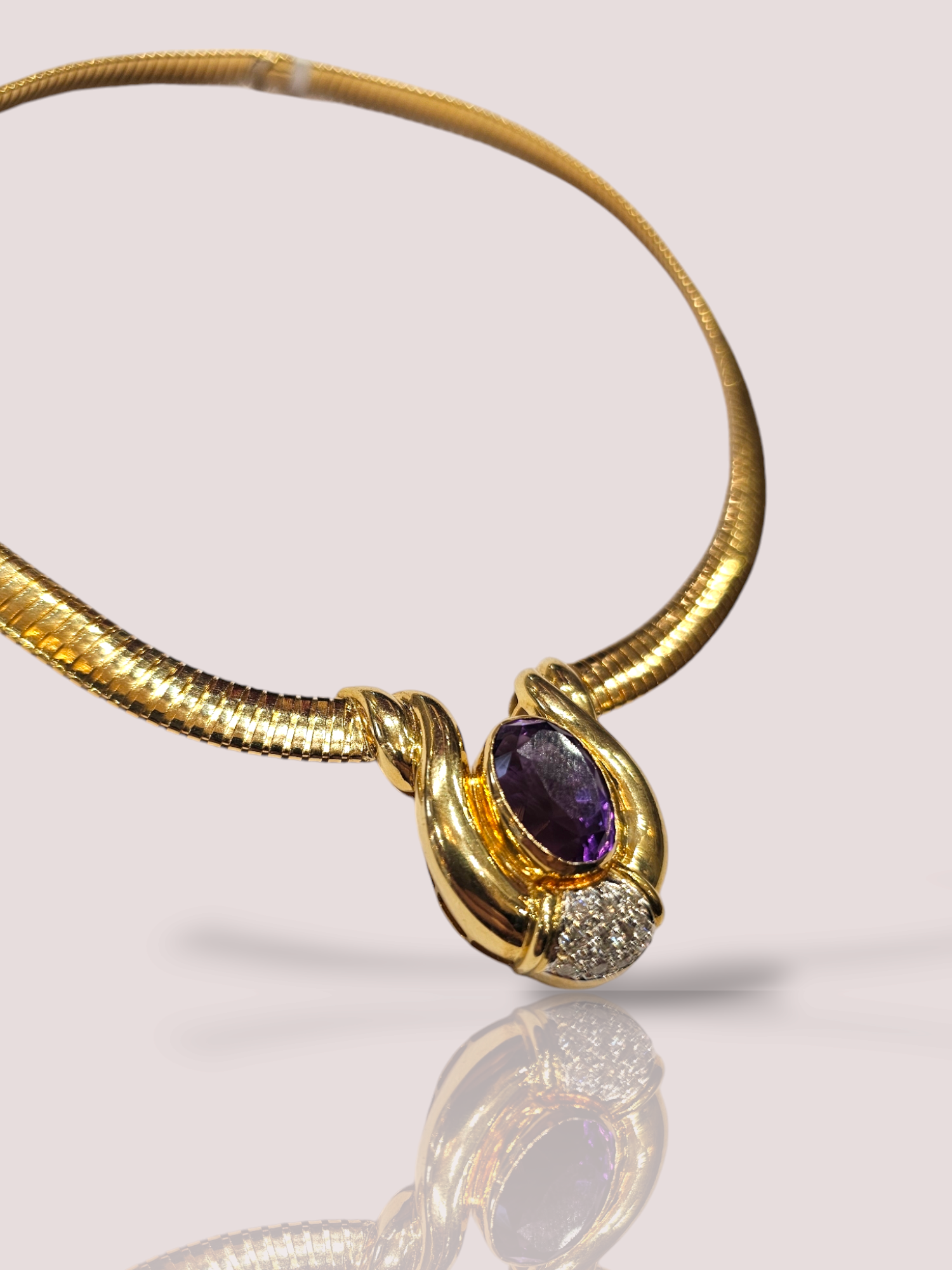 Dit prachtige juweel is gemaakt van 18 karaat geel goud en is versierd met een schitterende amethist en 11 glinsterende diamanten. Het collier is perfect voor speciale gelegenheden of als statement piece. Draag het alleen of gelaagd met andere kettingen voor een trendy look. Voeg glamour toe aan elke outfit met deze luxe en tijdloze halsketting. De ketting is 42 cm lang. De amethist is 1,5 bij 1 cm.
