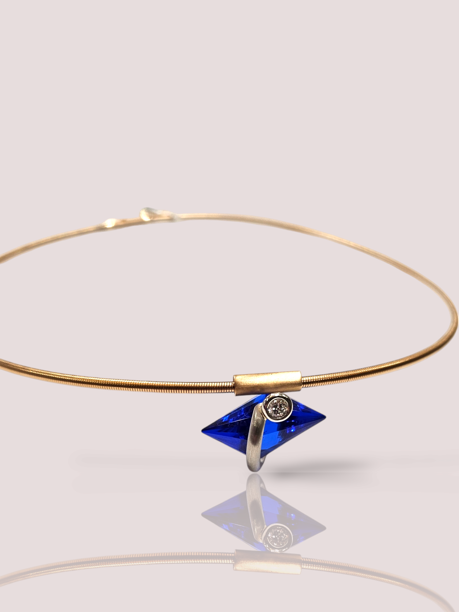 Dit prachtige vintage 18k roségouden collier van Bunz heeft een hanger van saffier en diamant, wat zorgt voor een tijdloze en elegante uitstraling. De collier kan op verschillende manieren gedragen worden, zowel bij casual outfits als bij formele gelegenheden. Combineer het met een eenvoudige blouse voor een chique look of draag het met een avondjurk voor een luxueuze uitstraling. Een veelzijdig sieraad dat elke outfit compleet maakt. De hanger is deels gemaakt van platina waarin de kegelvormige saffier wordt vastgehouden. 