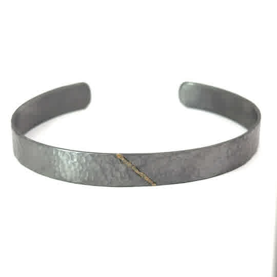 Diese Armspange aus feinem, geschmiedetem Tantal ist ein auffälliges Schmuckstück für Männer. Die Armspange kann alleine oder in Kombination mit anderen Armbändern getragen werden, um einen individuellen Look zu kreieren. Das elegante Design passt perfekt zu jeder Gelegenheit und verleiht Ihrem Outfit einen Hauch von Luxus und Eleganz. Ein Must-Have für jeden modebewussten Mann!