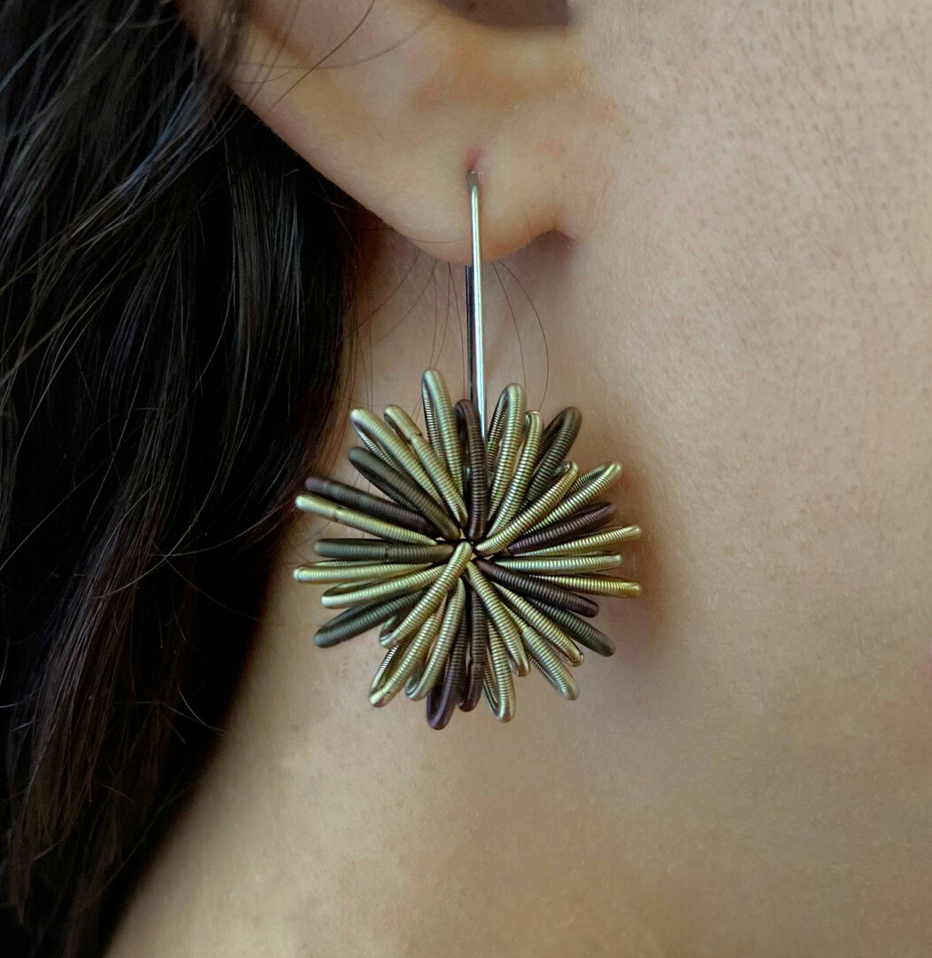 De Tobacco oorbellen van La Molla worden gemaakt van roestvaste stalen veren, hierdoor zijn de oorbellen erg licht. De ontwerpster van de sieraden, Tiziana Redavid, gebruikt afrikaans design als inspiratiebron voor het maken van de La Molla sieraden.