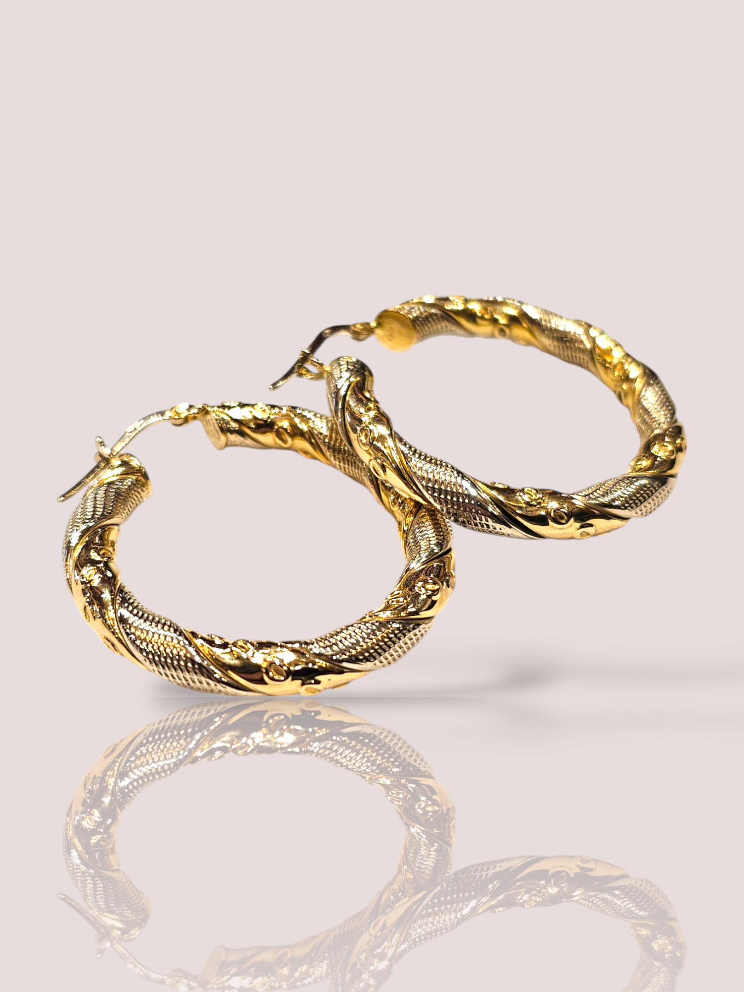 Deze vintage 18k geelgouden bewerkte creolen zijn voorzien van prachtige details en een klassieke uitstraling. De creolen zijn tijdloos en perfect te combineren met elke outfit. Draag ze met je favoriete jurk voor een elegante look of met een casual outfit voor een vleugje glamour. Een must-have item voor elke sieradencollectie! De diameter van de creolen is 3,5 centimeter en de ringen zijn 4 mm breed.