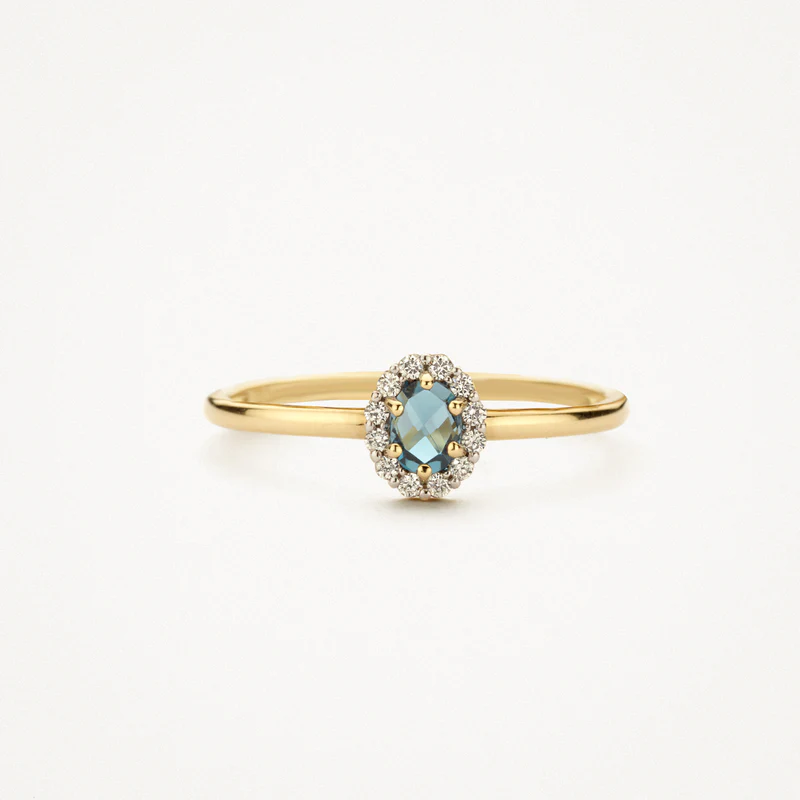 Deze 14k geelgouden ring springt in het oog door helderblauwe topaas omringd door zirkonia. De band heeft een doorsnede van 1,3 mm en de ring is prachtig te combineren met een of meer andere (aanschuif)ringen uit onze collectie.