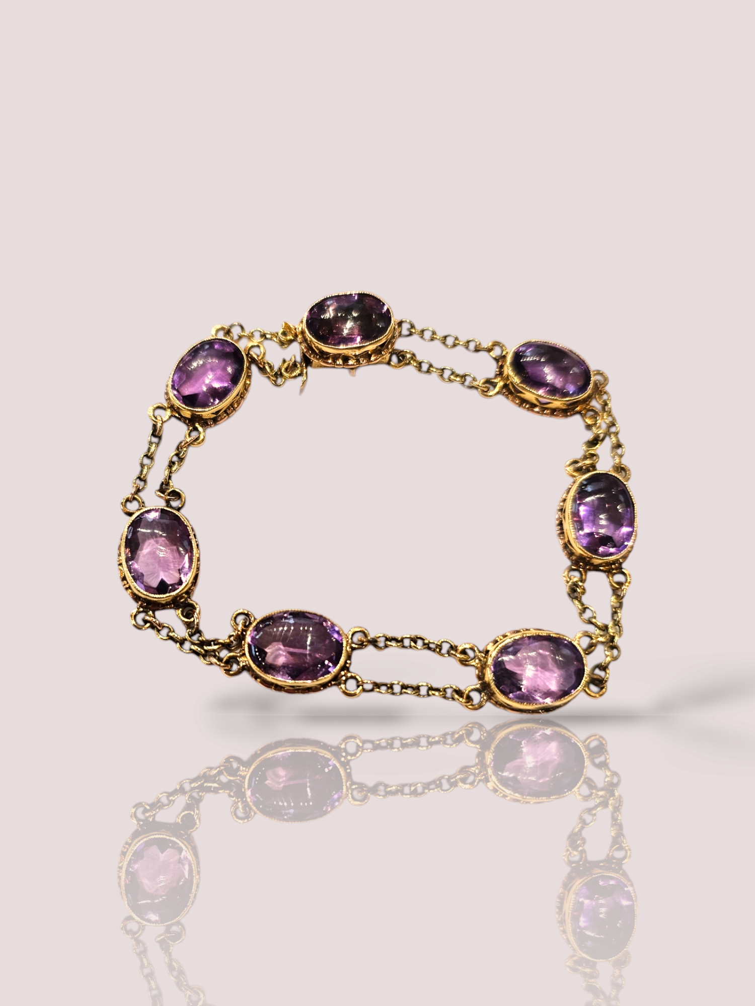 Deze prachtige vintage 14k geel gouden armband heeft cabochon geslepen amethisten als eyecatcher. De armband heeft een elegante uitstraling en is perfect om te dragen bij elke gelegenheid. De armband kan alleen worden gedragen voor een subtiele touch of gestapeld met andere armbanden voor een statement look. Een tijdloos stuk dat perfect is voor elke sieradencollectie. De armband is 20 cm lang en heeft 7 amethisten met kettinkjes ertussen.
