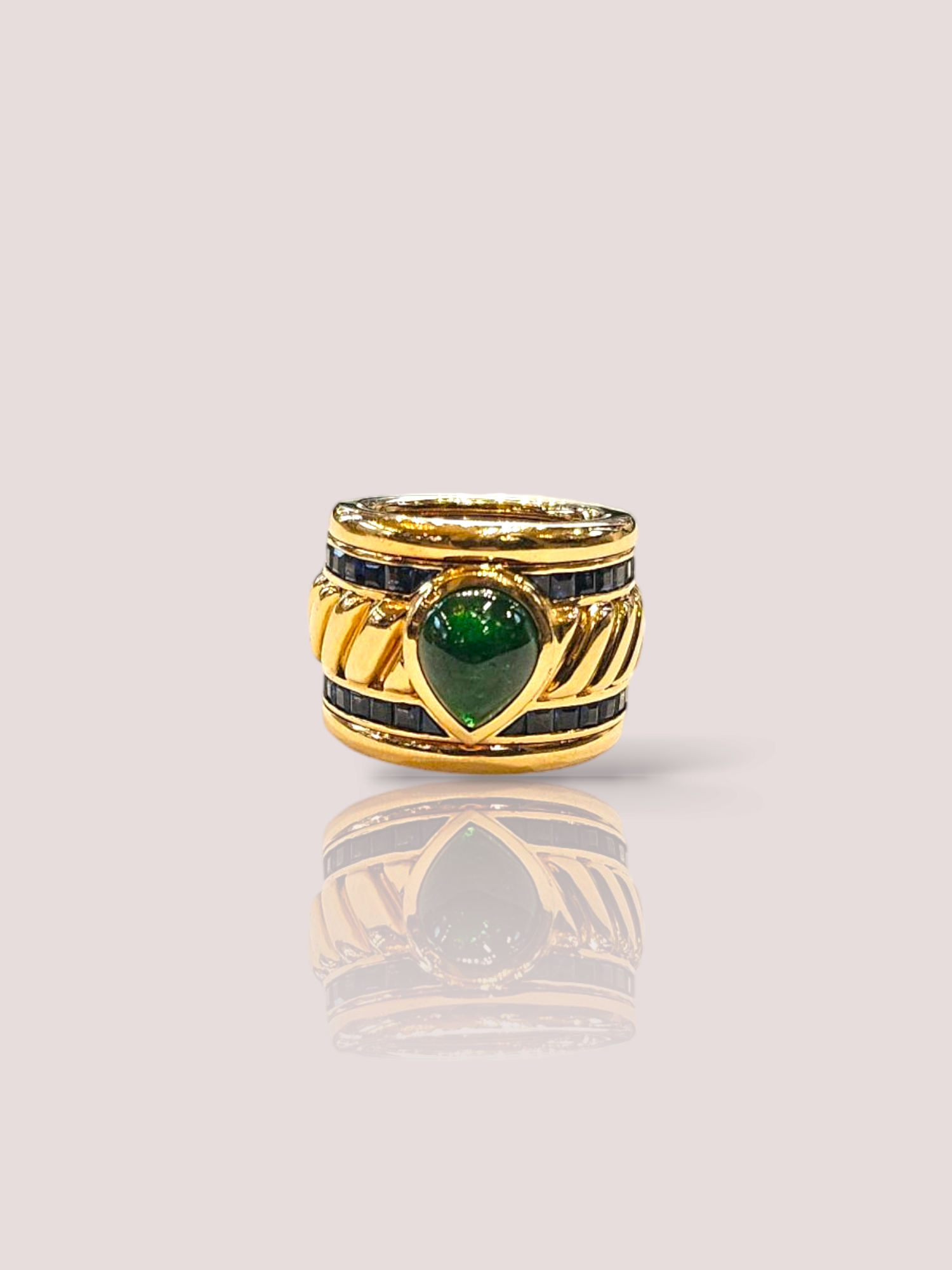 Deze vintage 18k geel gouden statement ring heeft prachtige saffieren en een cabochon geslepen smaragd, die schitteren in het licht. De ring is een echte eyecatcher en perfect voor speciale gelegenheden. Draag deze ring solo voor een subtiele touch of combineer hem met andere gouden sieraden voor een opvallende look. Voeg deze unieke ring toe aan je collectie voor een tijdloos en elegant stuk. De ring weegt 30,8 gram en heeft een fantastische afwerking. De ring is 1,7 cm hoog.

Om het geheel helemaal af te maken hebben wij ook bijpassende oorbellen bij deze ring!