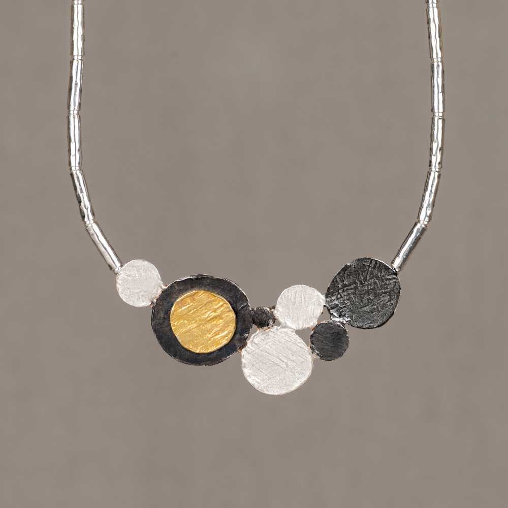 Collier gemaakt van 925 sterling zilveren buisjes in combinatie met een hanger van geoxideerd zilver en verguld. Combineer dit mooie collier met een paar oorsieraden, een armband en ring voor een complete look!