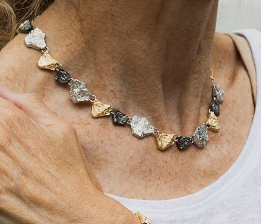 Bijzondere driekleurige ketting van 925 sterling zilver bestaande uit steenvormige hangertjes die op een ketting aan elkaar verbonden zijn.