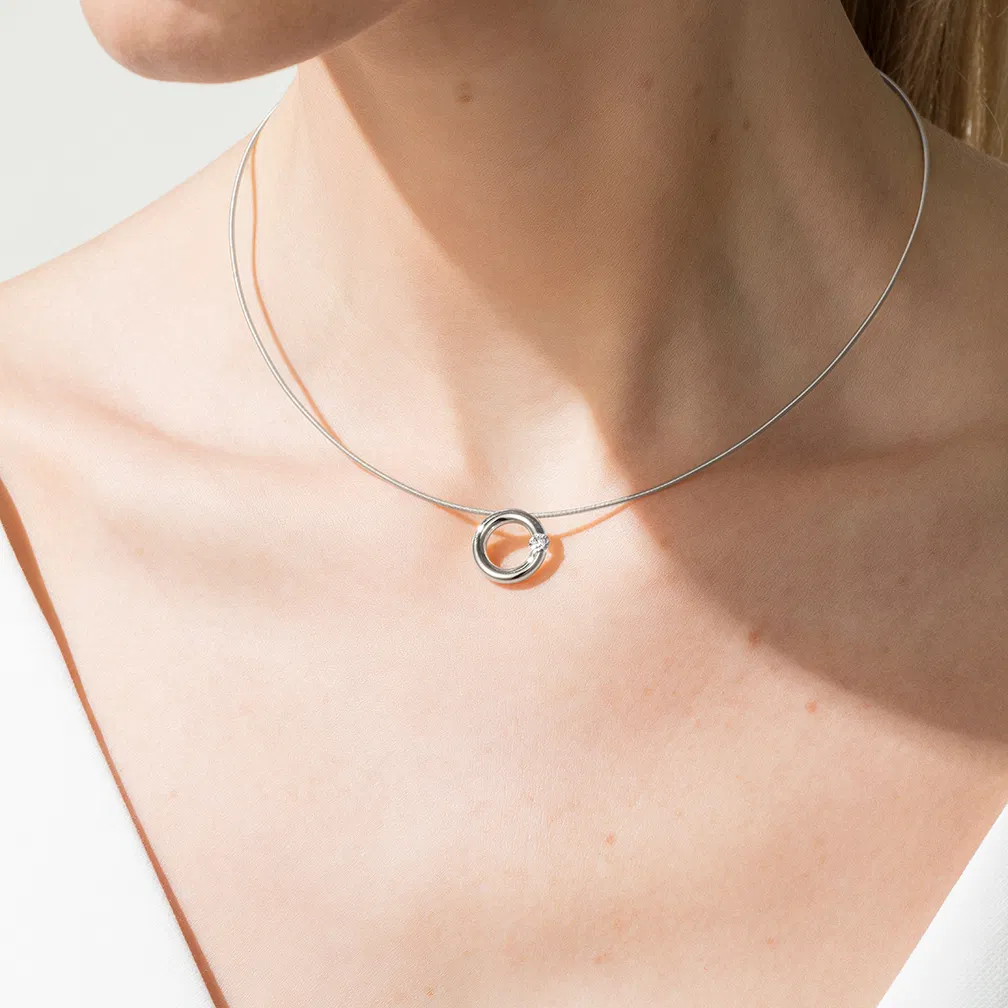 Een platina hanger Niessing model spanring 12 mm met een diamant briljant geslepen 0.10 crt VS TW.