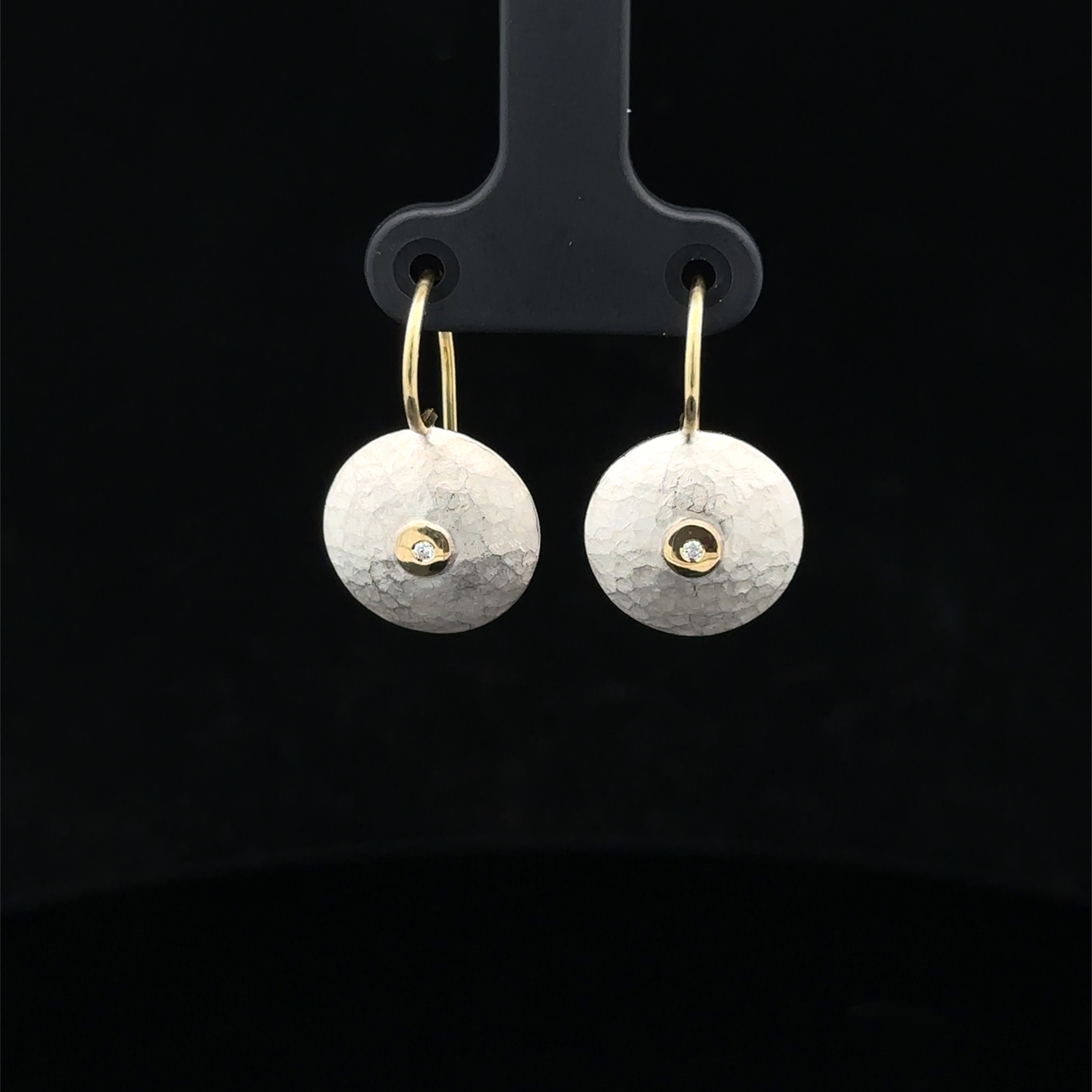 Dieser Ohrhänger aus Silber mit einem Bügel aus 750/-Gelbgold und kleinen Brillanten (je 0,01ct) ist ideal für den täglichen Gebrauch. Die kleine Linse (13mm) verleiht jedem Outfit einen eleganten Touch. Tragen Sie dieses Schmuckstück alleine oder kombinieren Sie es mit anderen Ohrringen für einen einzigartigen Look. Perfekt für jeden Anlass!