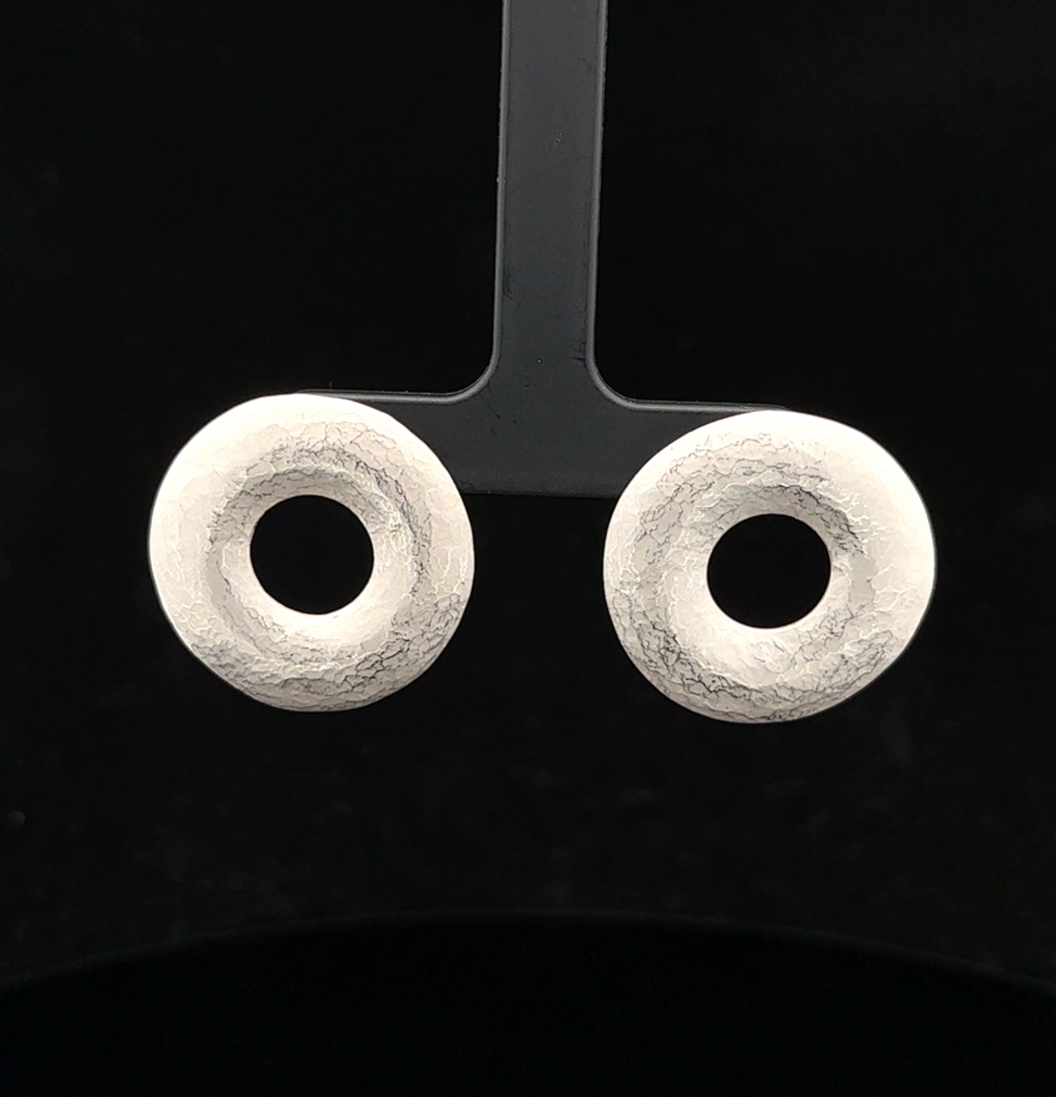 Die PENDANT_EARRINGS "Donut" sind aus Silber gefertigt und haben einen Durchmesser von 26mm. Sie sind mit Einhänger-Häkchen versehen, was sie besonders vielseitig macht. Trage sie alleine für einen schlichten Look oder kombiniere sie mit anderen Ohrringen für einen trendigen Layering-Effekt. Ein Must-Have für jede Schmucksammlung!