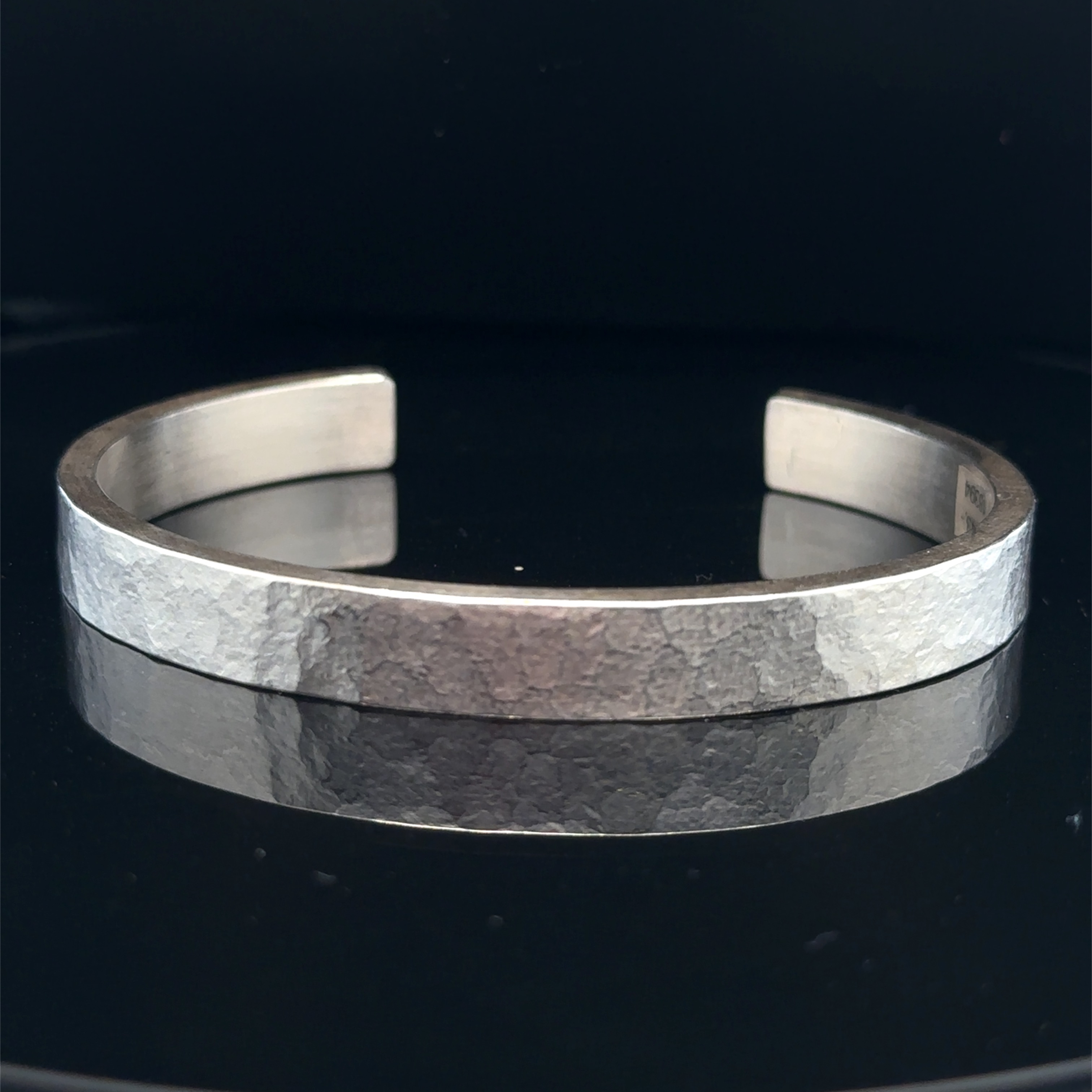 Diese Armspange aus 925er Silber wurde handgeschmiedet und besticht durch ihr rechteckiges Profil. Sie kann sowohl einzeln getragen werden als auch in Kombination mit anderen Armbändern. Ein zeitloser und eleganter Schmuck, der jedes Outfit aufwertet.