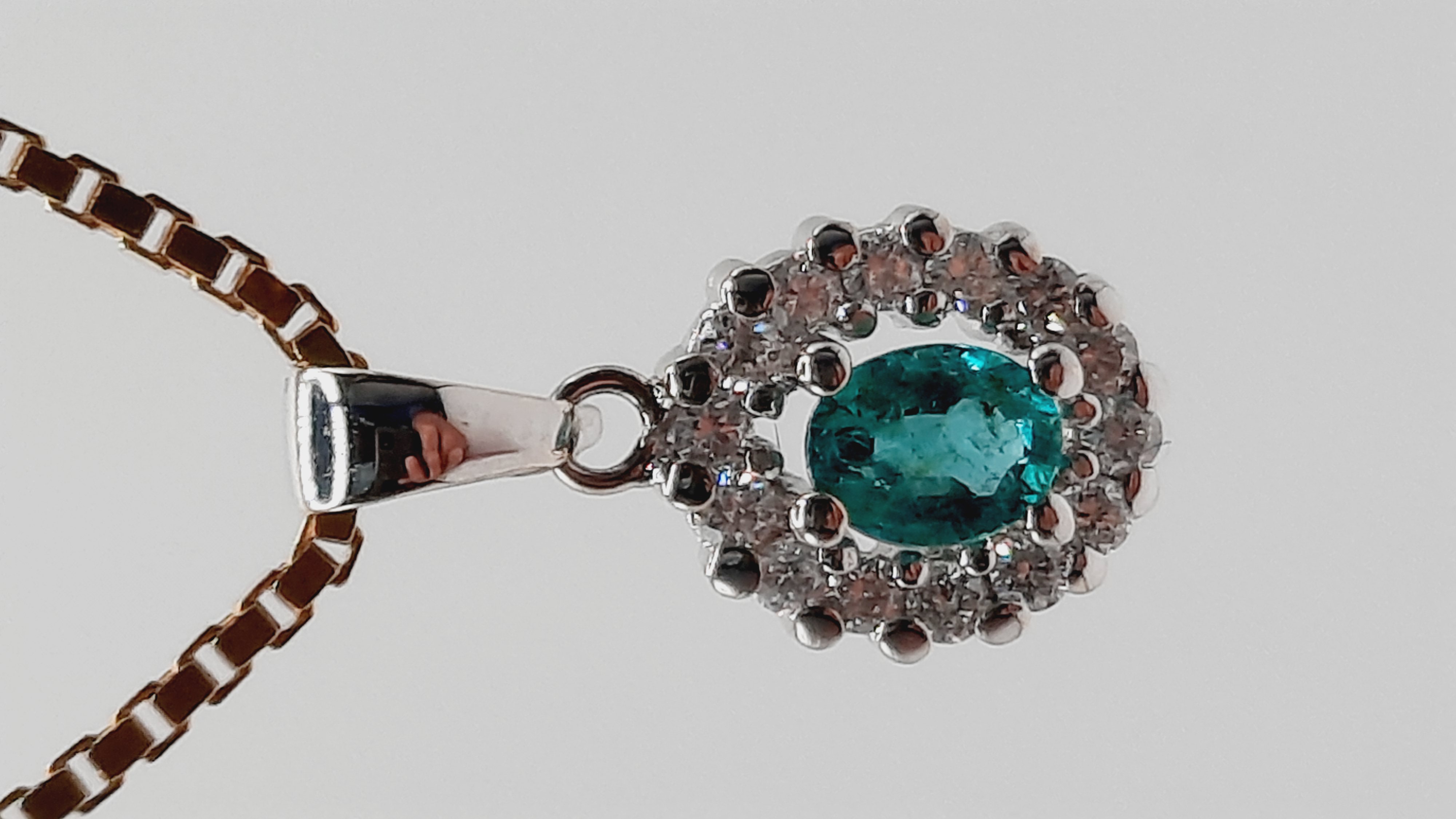 De Diamant-Smaragd Hanger 18kt (Modelnummer: 0002266) bevat een briljante geslepen diamant van .21 ct (SI1, H) en een smaragd, geplaatst in 18kt witgoud. Deze elegante hanger van 18 mm past perfect bij zowel formele als informele gelegenheden. Draag het met een slanke gouden ketting voor een verfijnde look. Perfect voor dagelijks gebruik en speciale gelegenheden.