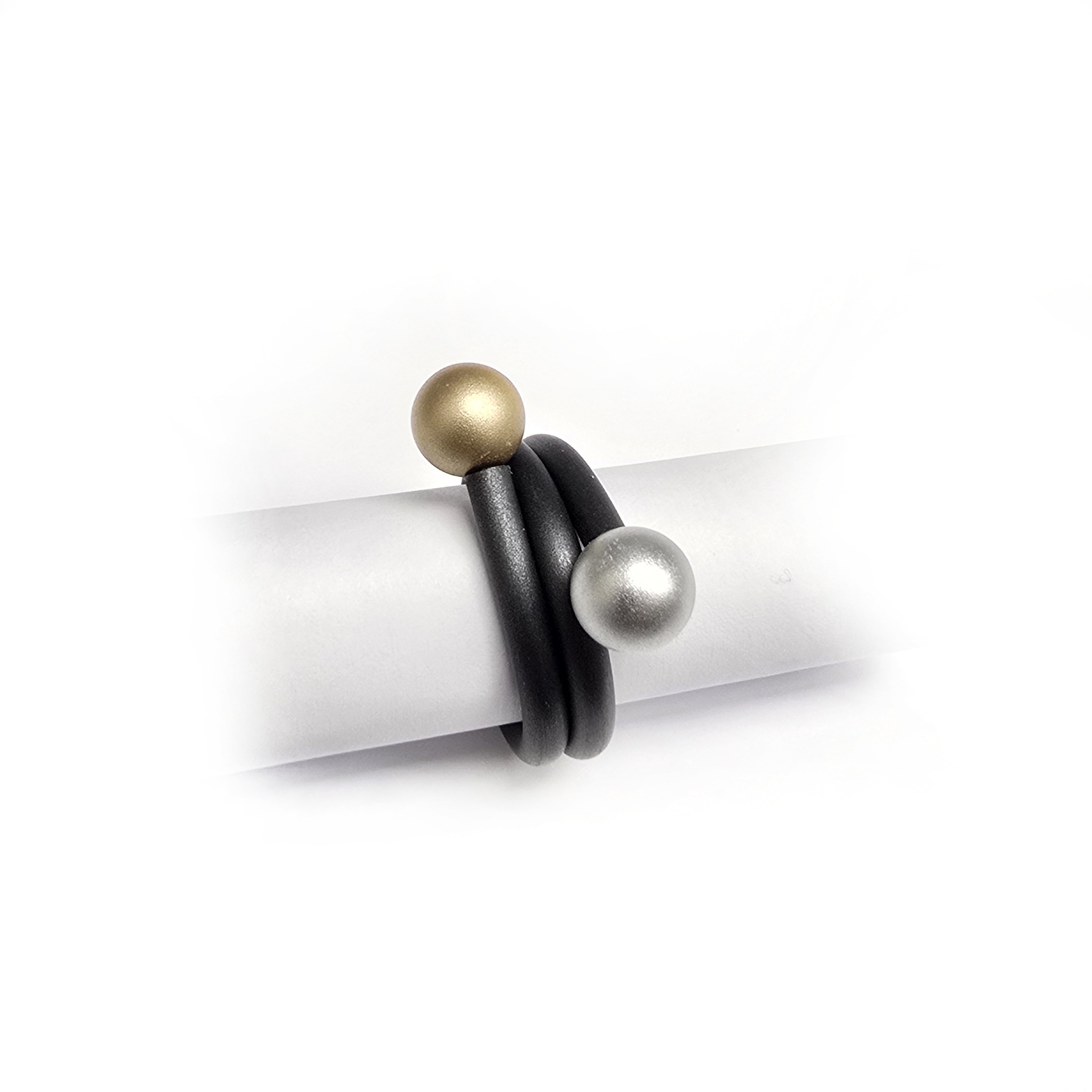 Rubberen ring met goud/zilverkleurige aluminium bolletjes.