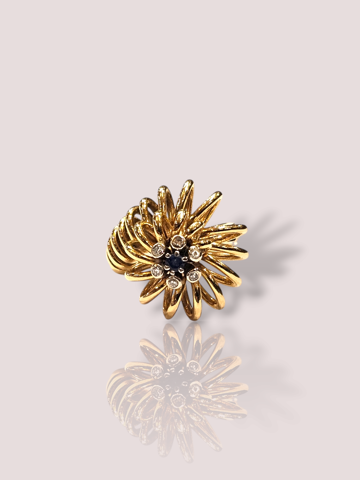 Deze prachtige vintage 18k spiraal ring is bezet met een saffier en 6 diamanten. De combinatie van deze edelstenen zorgt voor een elegante en tijdloze uitstraling. De ring is perfect voor speciale gelegenheden of als dagelijkse accessoire. Draag hem alleen of combineer met andere ringen voor een unieke look. Een must-have voor elke sieradencollectie! De ring is 2 cm hoog. De saffier heeft een diameter van circa 3 mm. De ring kan op maat gemaakt worden.