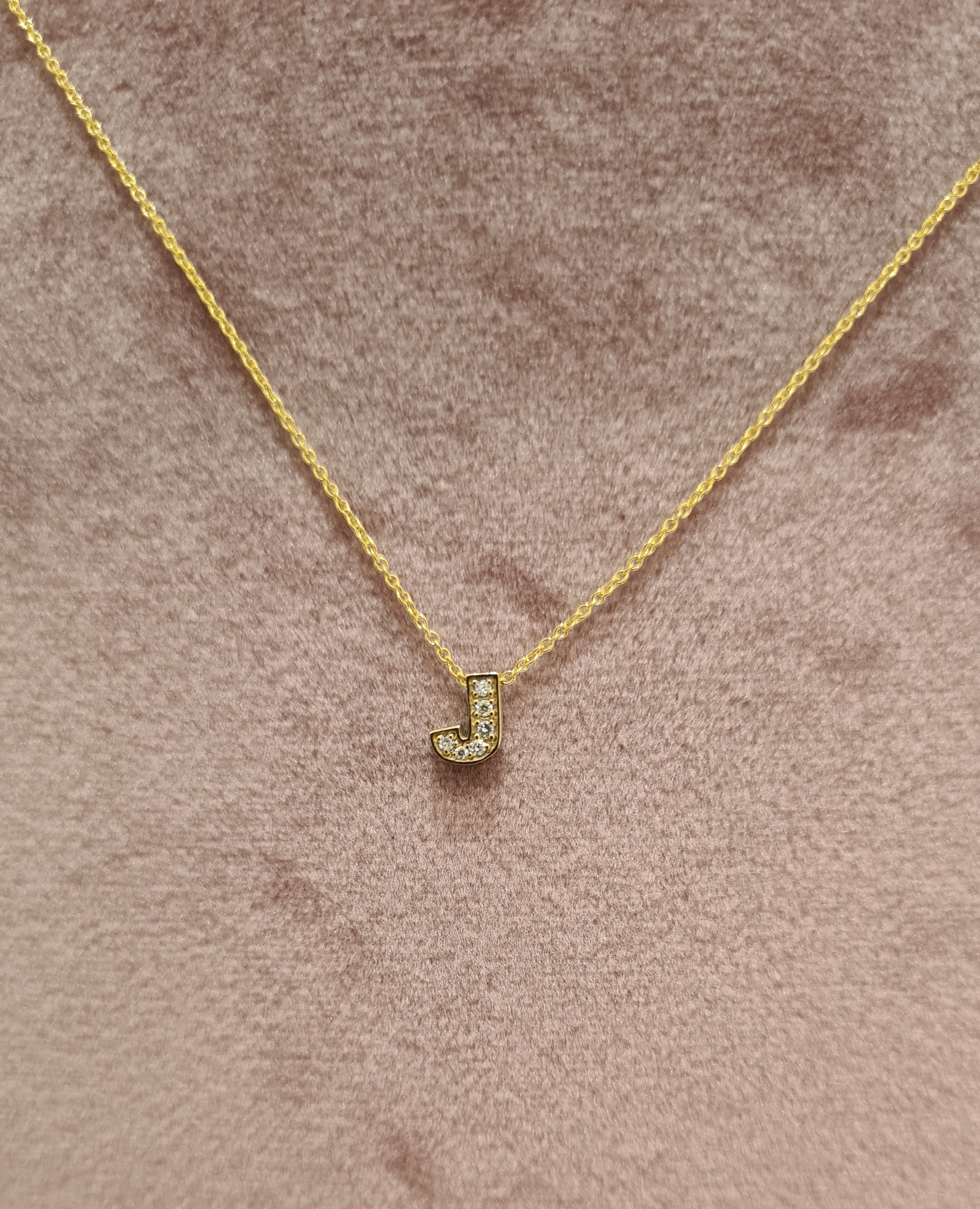 Deze prachtige One Pave Initial Necklace J heeft een delicate ketting met een subtiele letterhanger, volledig ingelegd met fonkelende zirkonia steentjes. Het is perfect voor dagelijks gebruik of om je outfit een persoonlijk tintje te geven. Draag het alleen voor een minimalistische look of combineer het met andere kettingen voor een trendy gelaagde stijl. Maak een statement met deze gepersonaliseerde ketting!
