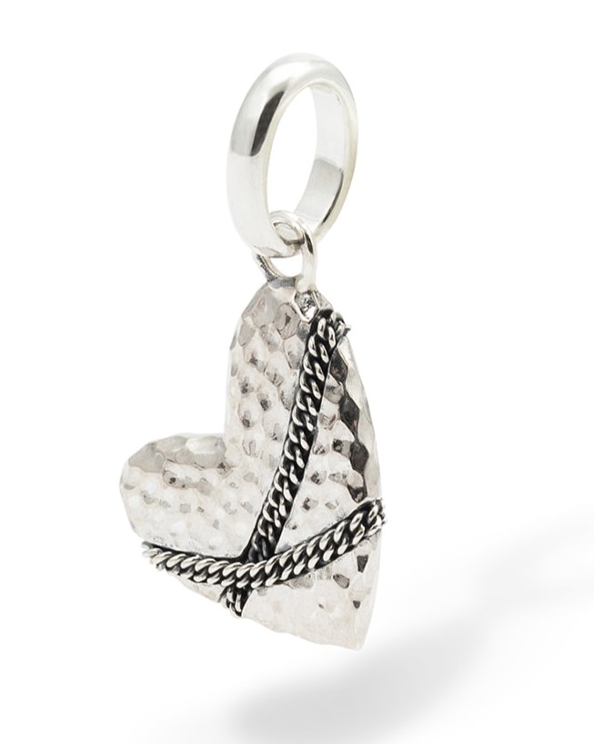 Raak de mensen die op je pad komen, met onze statement Heart Hanger in Zilver. Vier de puurste liefde in haar meest bekende vorm: het hart. Speciaal handgemaakt voor degenen die hun liefde durven uiten, gepresenteerd als een unieke mix van strak minimalisme met een rebels randje. De details van dit sieraad bestaan uit kruisende kettingen, symbool voor de versteviging van een verbinding. Combineer de hanger met een van onze kettingen, of voeg hem toe aan de ketting die je draagt, ter herinnering aan jouw oprechte passie. Gemaakt van gerecycled 925 sterling zilver, ontworpen in Amsterdam en zorgvuldig gemaakt in Zuidoost-Azi&euml;. De Heart Pendant is graveerbaar; maak hem nog persoonlijker met een unieke boodschap op de achterkant. Voor wie open jij je hart?