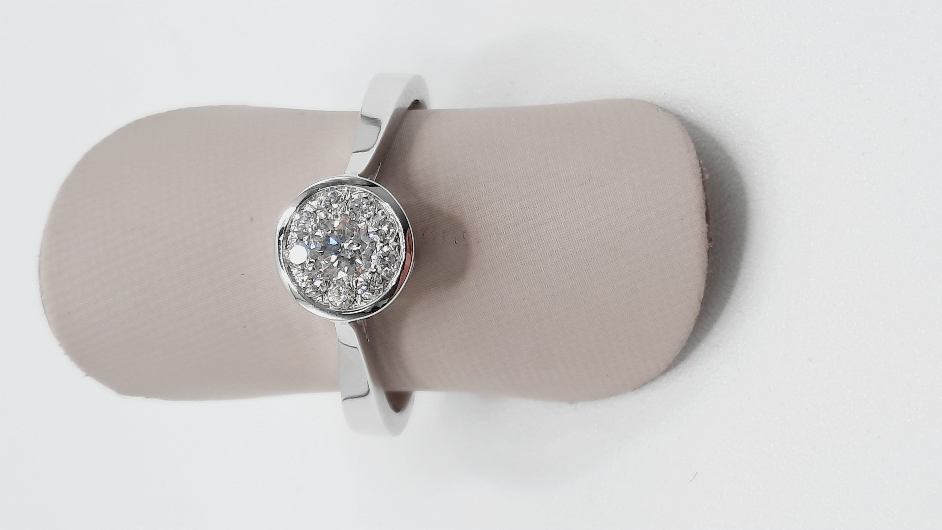 Deze gouden ring BREA-0002662 van een onbekend merk straalt elegantie uit met zijn 18-karaats witte goud en negen ronde diamanten (0.25ct, G-kleur, SI1-zuiverheid). Geschikt voor maat 17. Draag deze verfijnde ring solo of gecombineerd met andere sieraden voor een tijdloze en chique look. Perfect voor elke speciale gelegenheid.