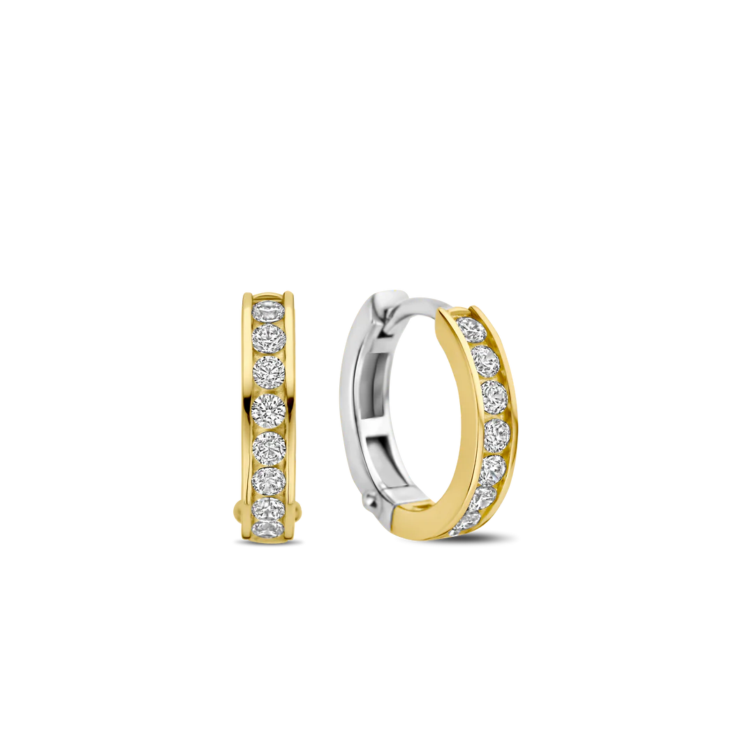 Hul jezelf met moderne elegantie met de TI SENTO gold-plated silver Hoop Earrings 7973ZY. Gemaakt van 925 sterling zilver en verguld met een stralende goudkleur, hebben deze oorbellen twee kleine hoepels versierd met een verblindende rij rechthoekig geslepen witte cubic zirconia stenen. De geometrische vorm van de stenen voegt een vleugje gedurfde verfijning toe aan het klassieke hoepelontwerp. Minimalistische stukken die veel zeggen zonder woorden, deze oorbellen zijn een must-have voor elke sieradencollectie. Het stralende geelgoudkleurig en de sprankelende cubic zirconia stenen creëren een betoverend spel van licht en textuur. Verhoog je dagelijkse look met deze stemming-verhogende juwelen. Draag ze alleen voor een minimalistische uitspraak of gecombineerd met andere TI SENTO oorbellen voor een gepersonaliseerde touch die vertrouwen en aantrekkingskracht uitstraalt. Laat deze oorbellen de vonk zijn die je innerlijke uitstraling ontsteekt. Met zorg vervaardigd voor gevoelige huid, zorgen deze nikkelvrije en hypoallergene oorbellen voor langdurig comfort en kwaliteit.

