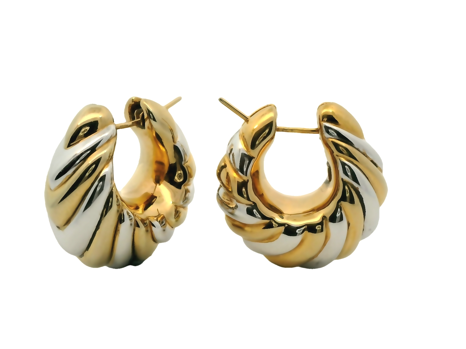 Deze elegante oorringen zijn gemaakt van 14 karaat bicolor (9.37 gr) en hebben een luxueus gedraaid ontwerp met een prachtige combinatie van geelgoud en witgoud. De geribbelde structuur zorgt voor een speels lichtspel, waardoor de oorbellen extra glans en diepte krijgen. Dankzij de stevige push-back sluiting blijven ze comfortabel en veilig zitten. Het tijdloze design maakt deze oorringen perfect voor zowel dagelijkse elegantie als speciale gelegenheden. Een verfijnde toevoeging aan elke sieradencollectie!
