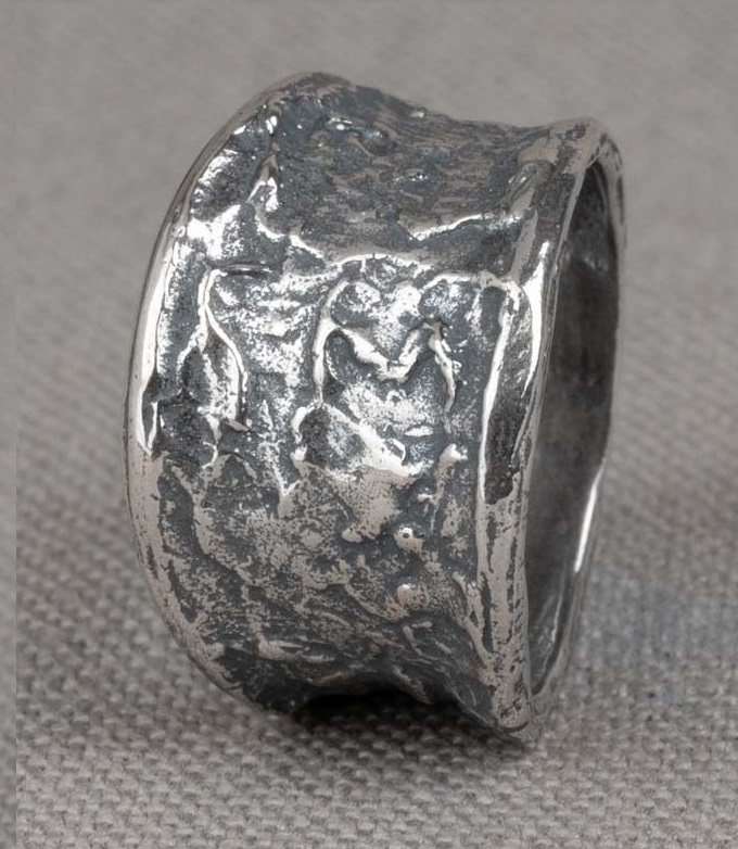 Ring uit de Silver-collectie van Jéh Jewels, gemaakt van 925 geoxideerd sterling zilver. De ring heeft een grove structuur en heeft een uiteenlopende breedte. Aan de bovenkant is de ring 14 mm breed en aan de onderkant is de ring 7 mm breed. De ring past goed met de bijpassende sieraden van Jéh.