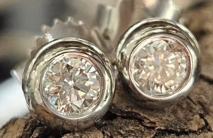 14 karaat wit gouden speciaal geproduceerde oorstekers. Met briljant in een witgouden Donut zetting met steker en pouchette. Briljant  2x 0.16 crt. VS1-TW.