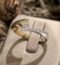 14 Karaat geel- met witgouden slagring met daarin totaal 0.25 crt briljant G/VVS1.