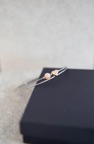 Lief edelstalen armbandje met zonnesteen en rosé kleurig hartje.